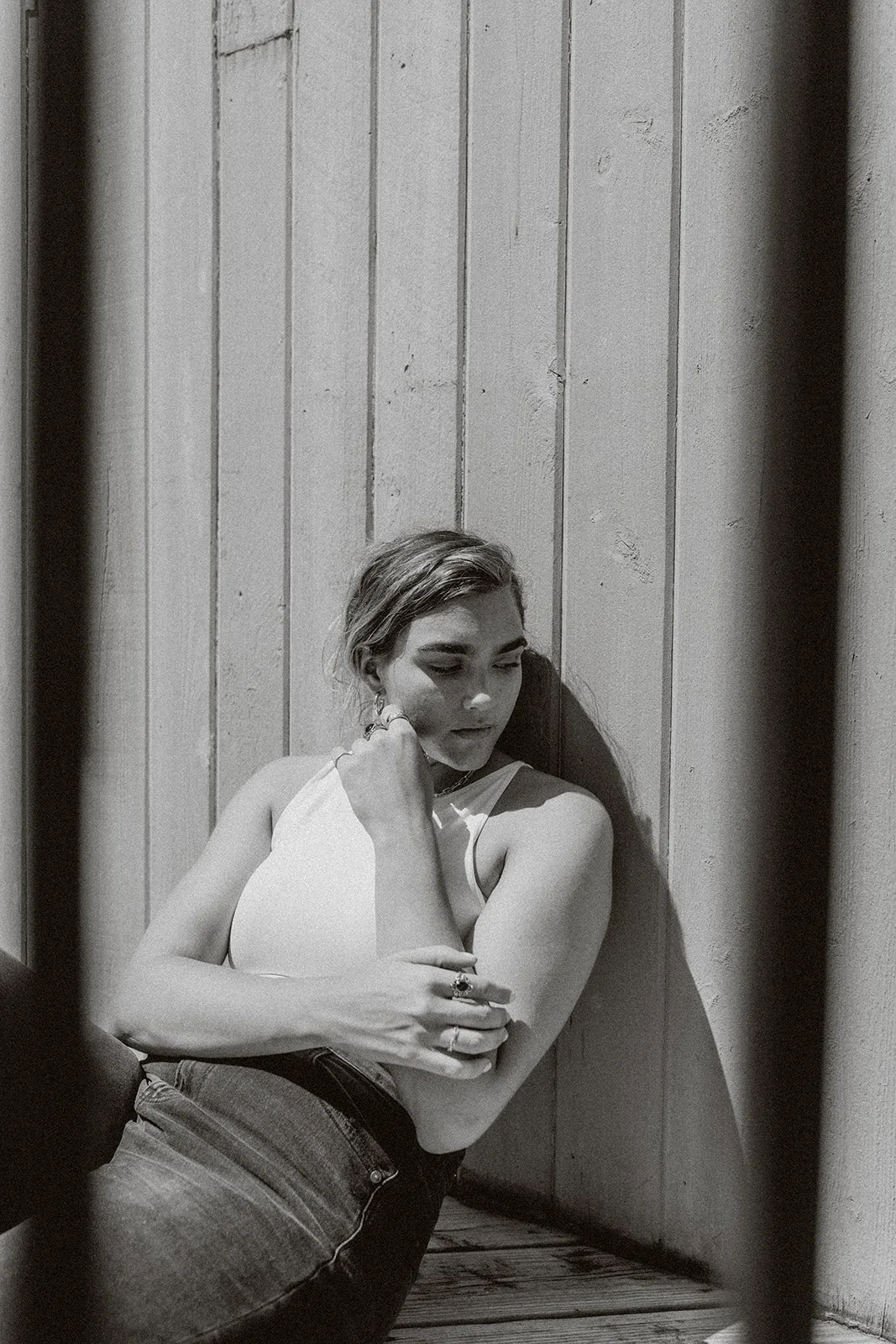 Black and white portrait of woman leaning on wall at Wrightsville Beach, North Carolina.