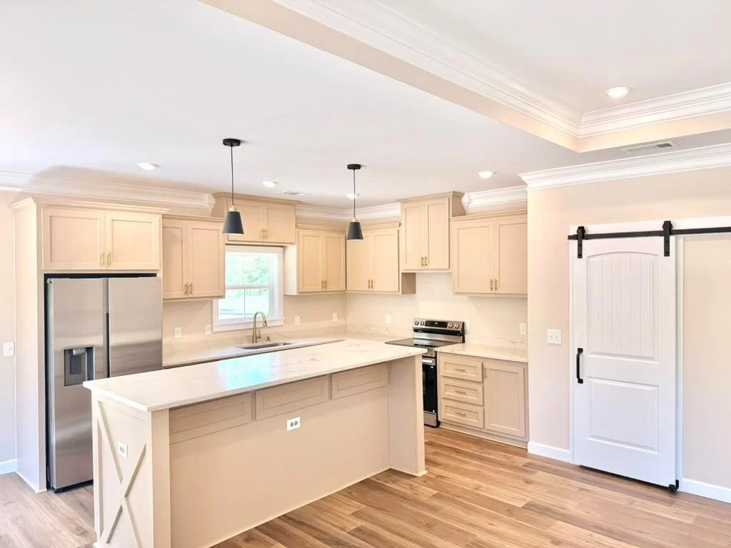 Kitchen in a newly constructed home featuring quartz countertops, an oversized island, and custom cabinetry.