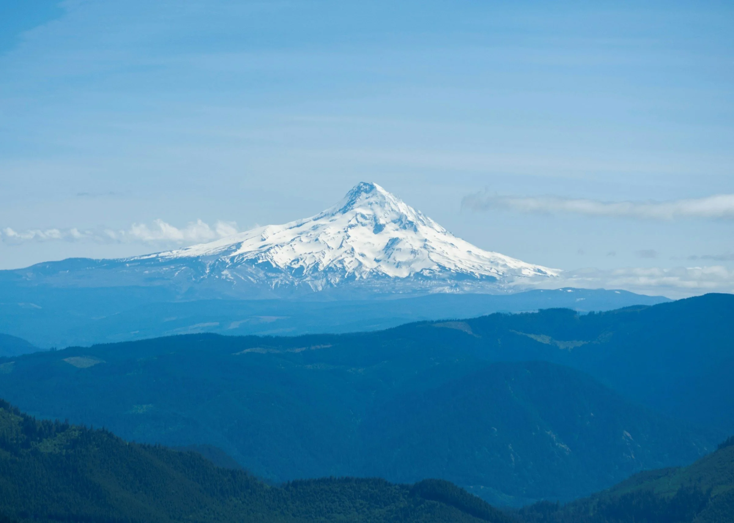 Snow-capped Mt. Hood rising above forested ridges in Oregon
