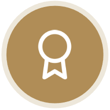 Gold medal icon with white outline and ribbon on a beige background.