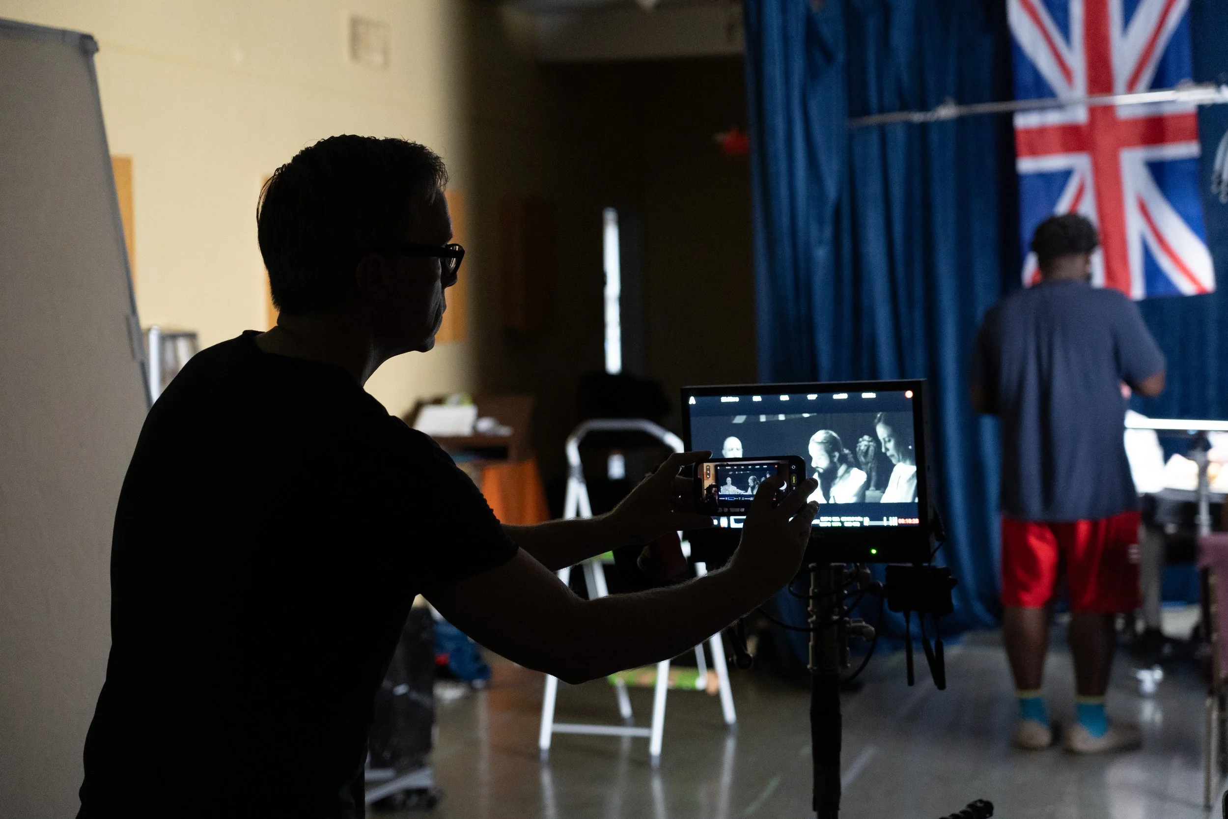 A camera operator filming performers during a production shoot.
