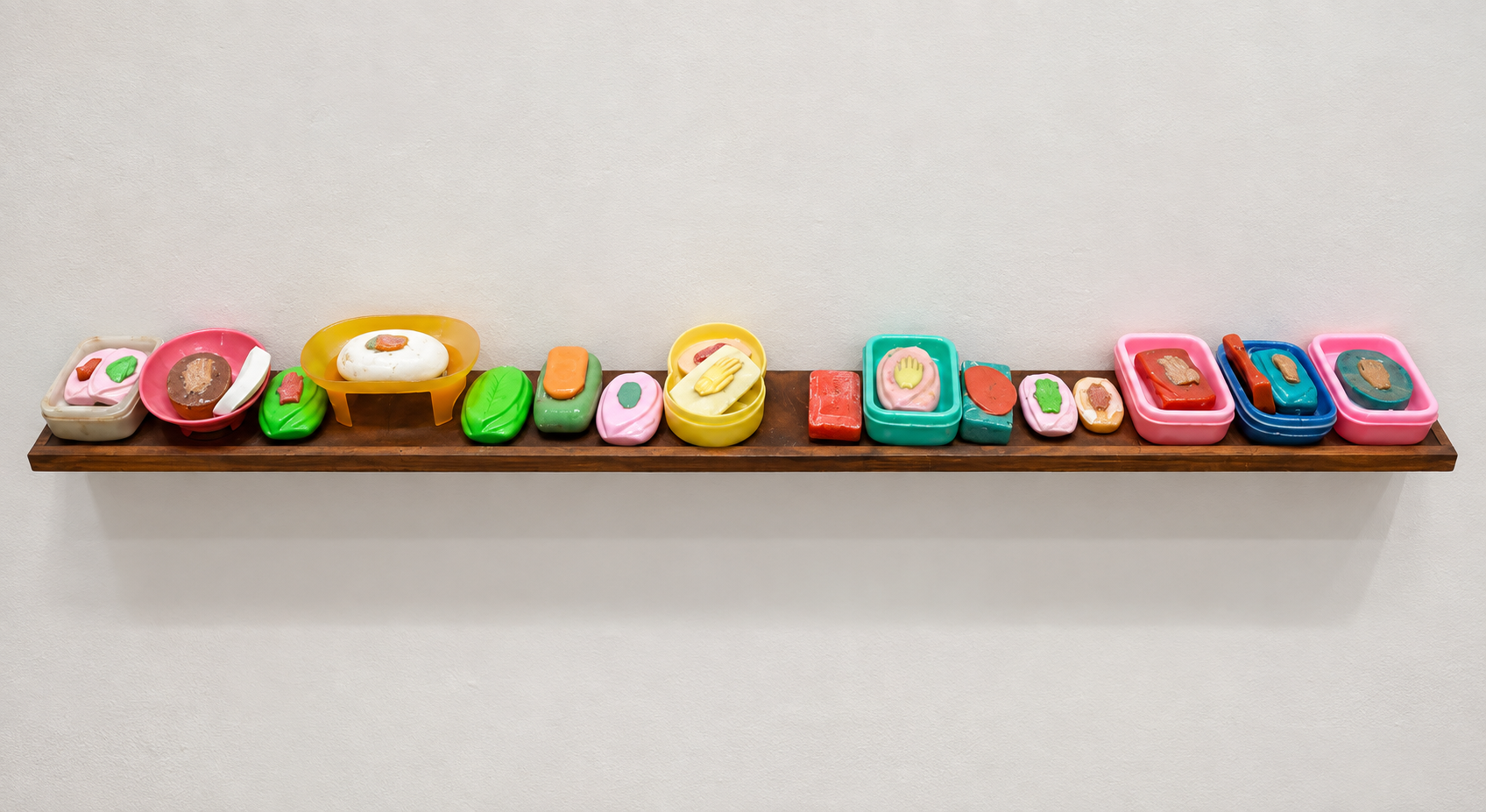 Glossy Candy Sculptures on a Wooden Shelf.png