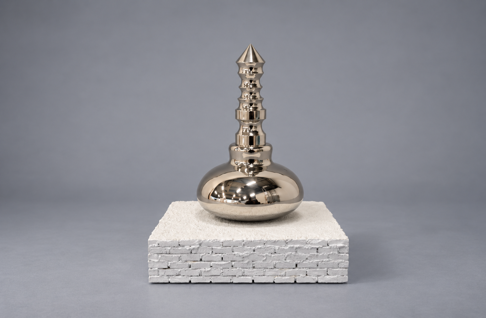 Reflective Silver Spire on Textured Pedestal.png