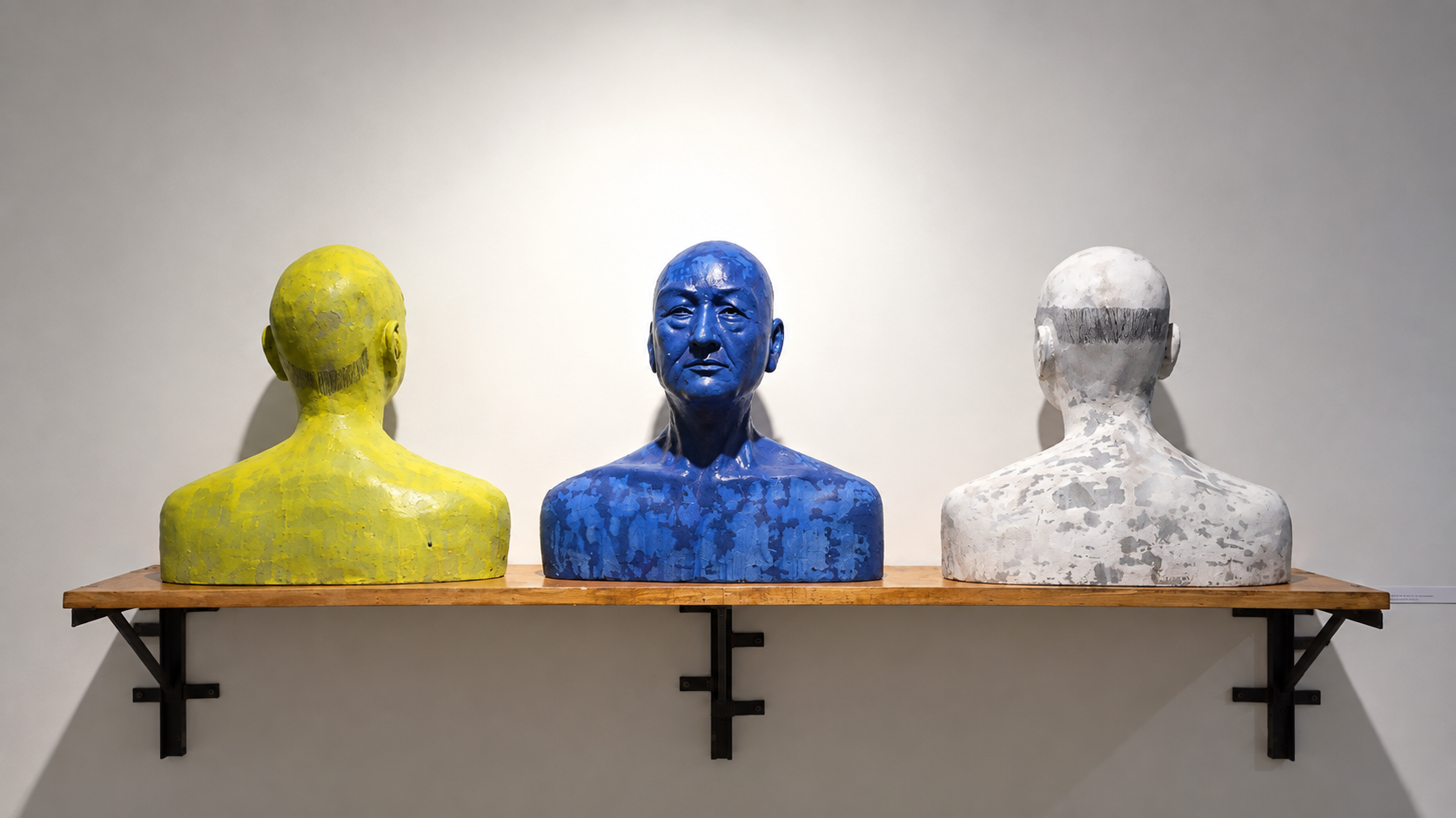 Three Textured Busts on a Gallery Shelf.png