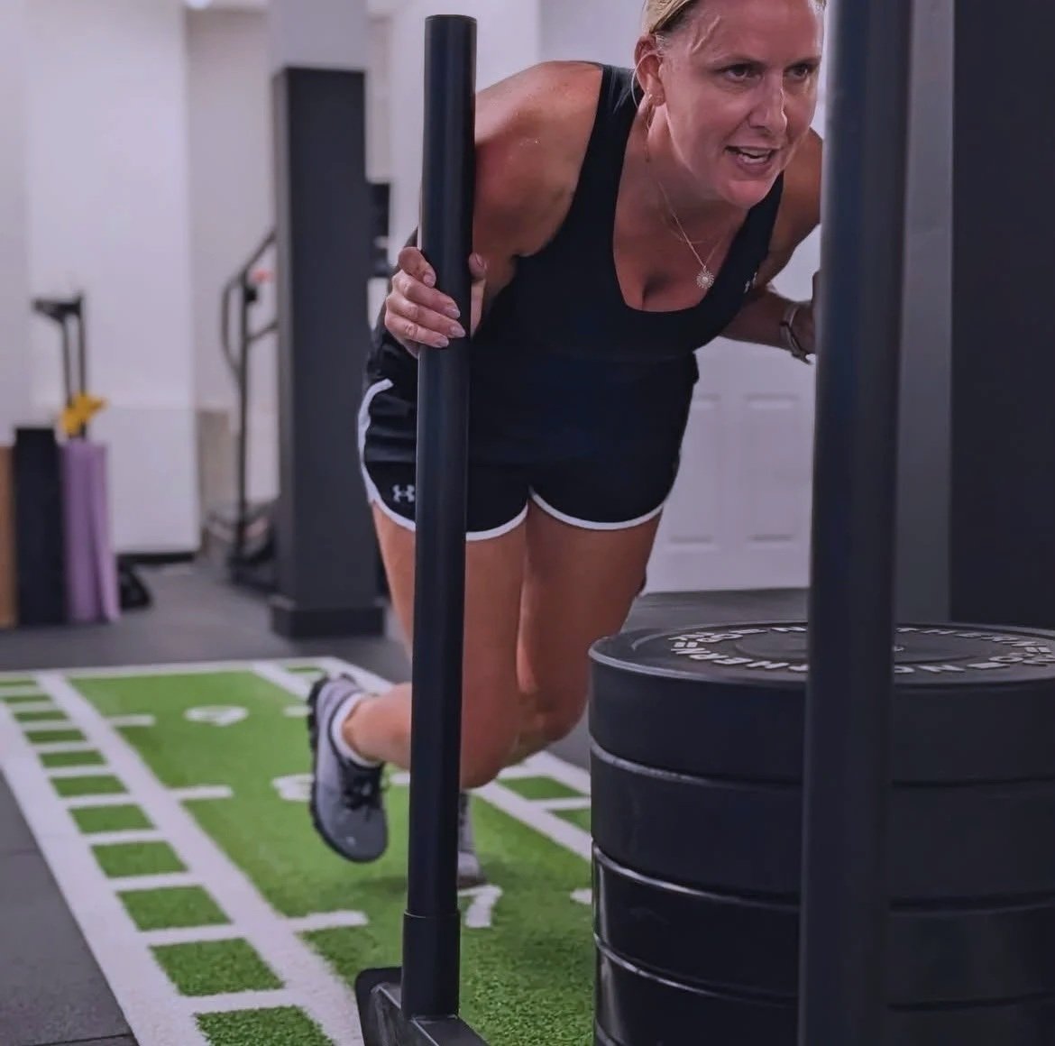 woman pushing weights in a gym