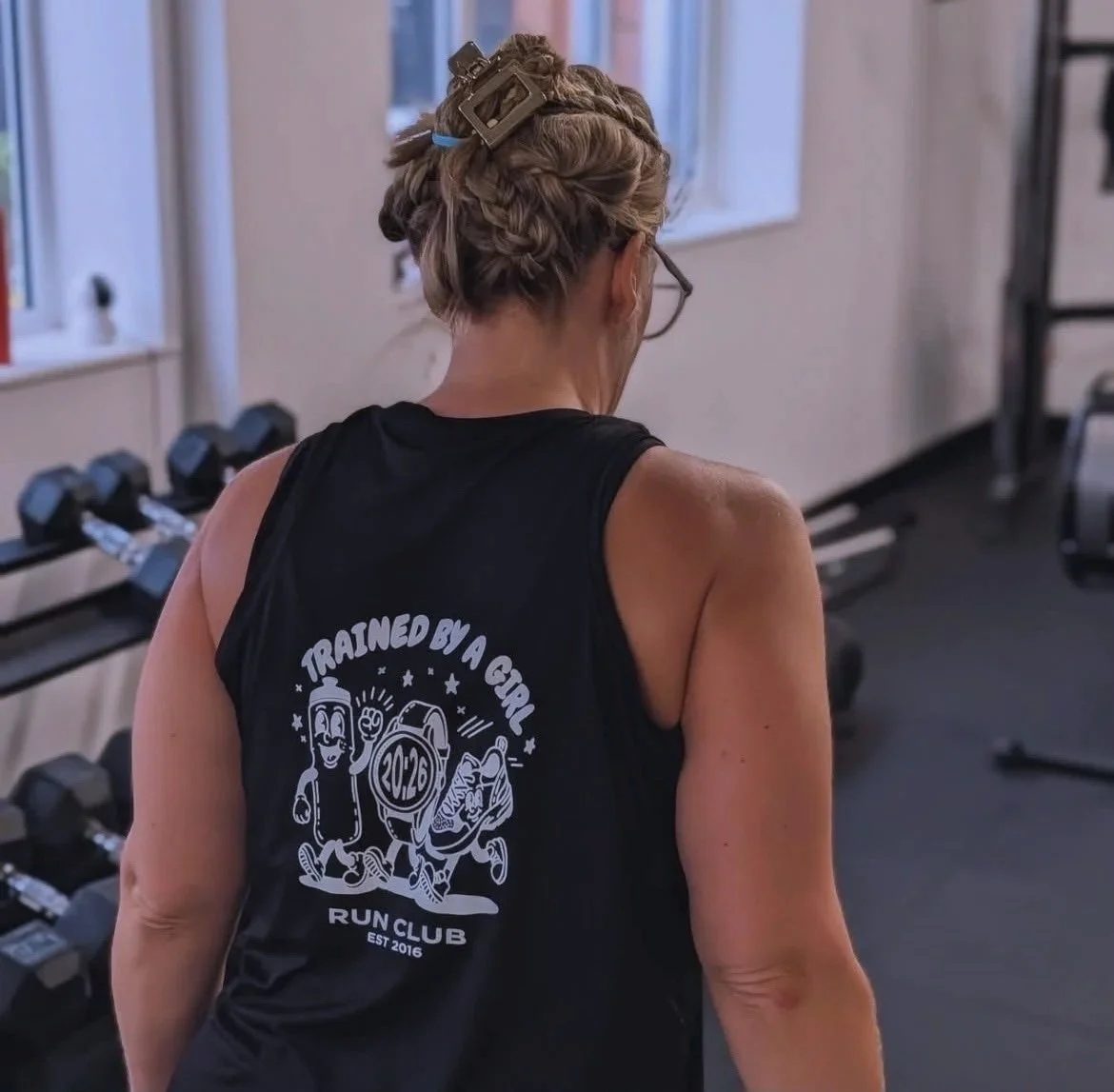 woman wearing trained by a girl tshirt in the gym