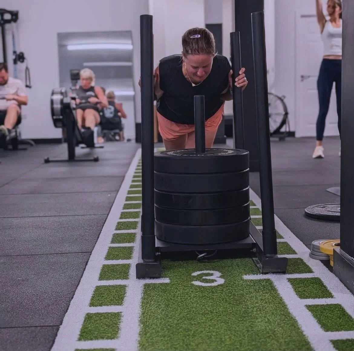 woman pushing weights in the gym