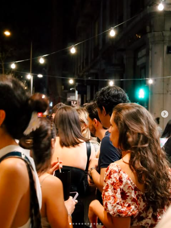 Fête de la Musique à Lyon à G.APERO : Groupe de personnes dans une rue animée la nuit, éclairée par des guirlandes lumineuses.