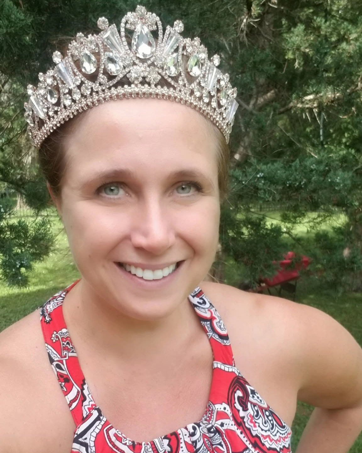 Woman in a rhinestone tiara in a red print dress
