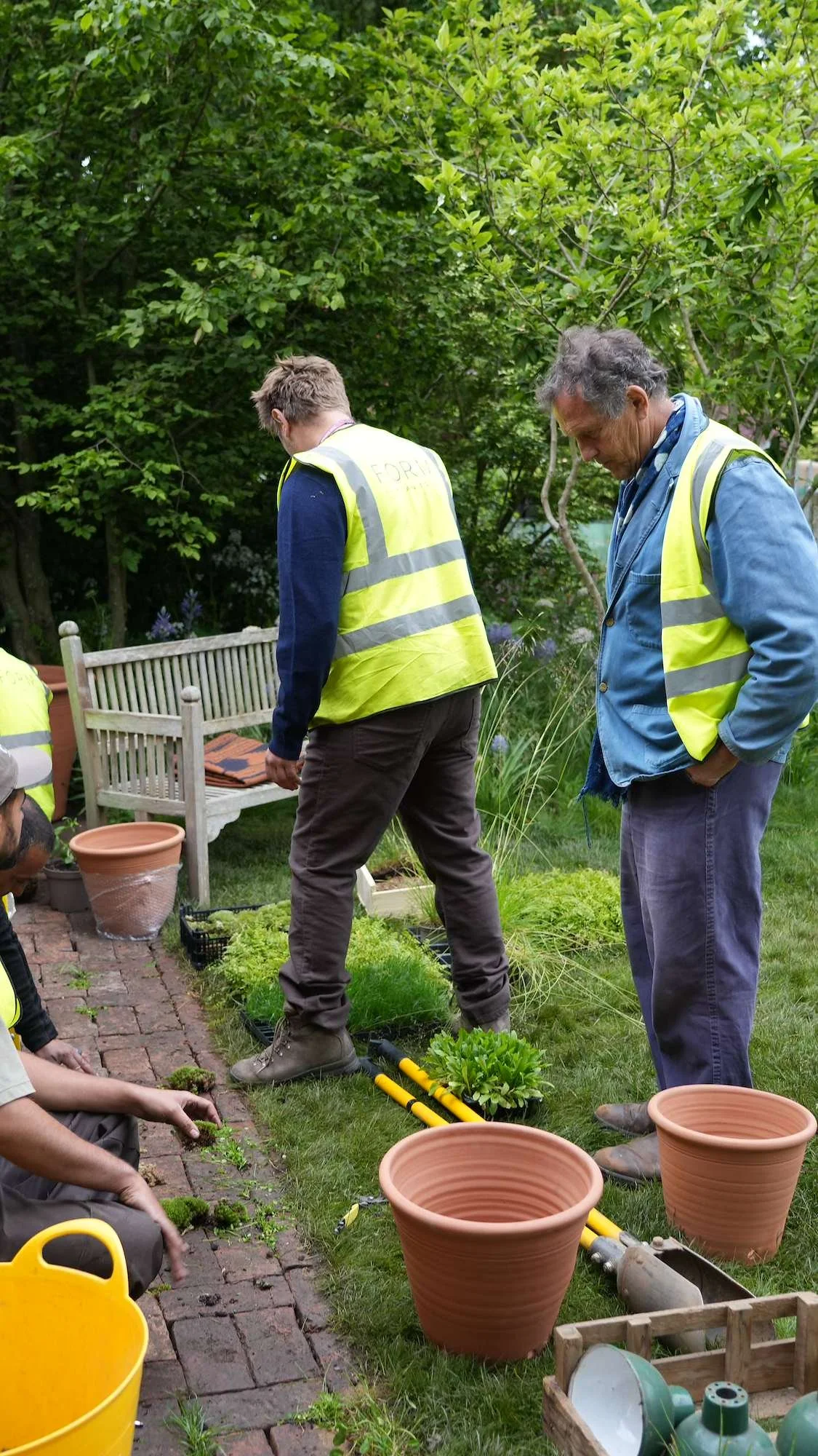 Form Plants team in hi-vis discussing planting with a garden designer on a show garden build