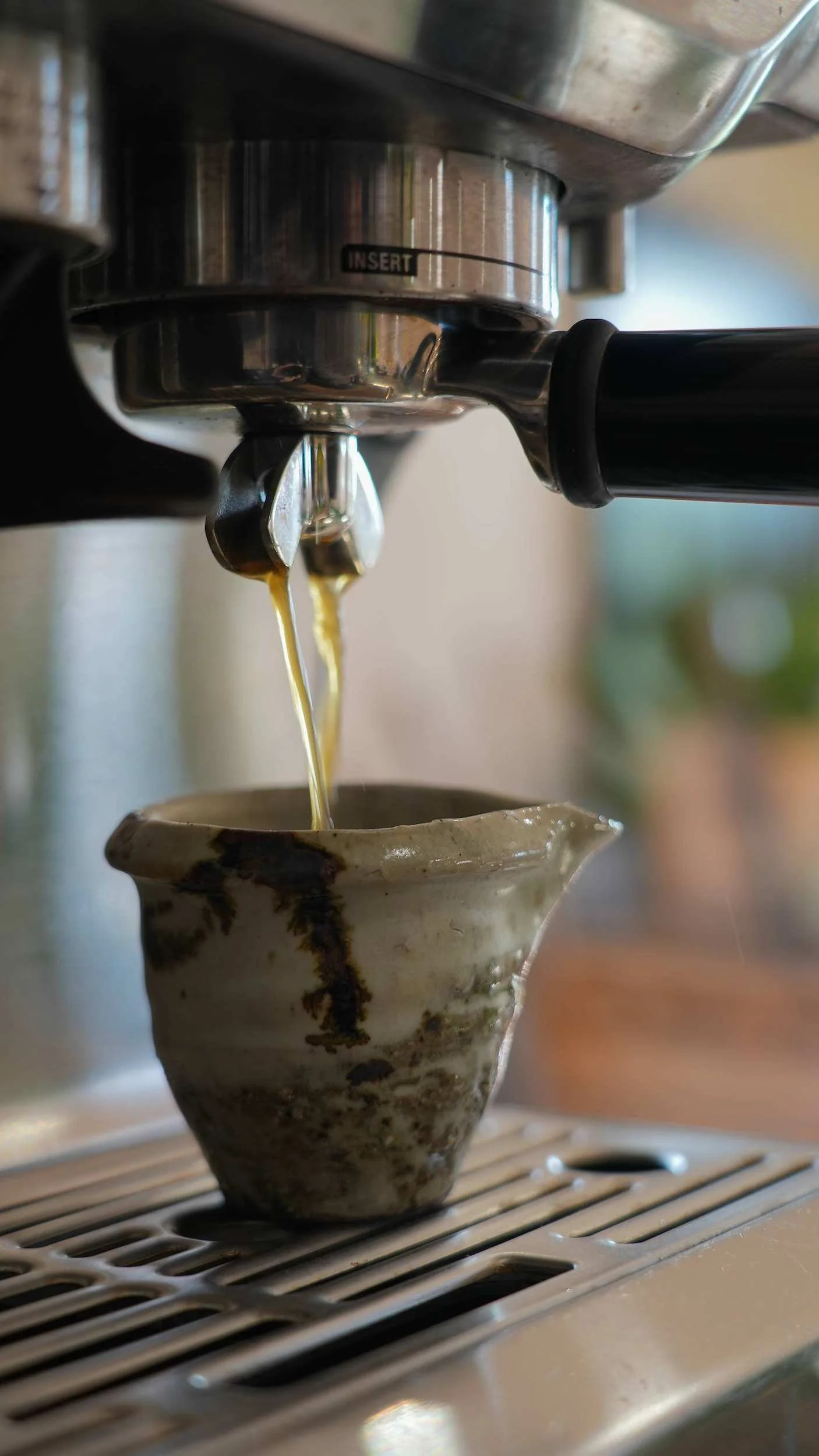 Espresso pouring into a handmade ceramic cup at the Form Plants Row Town showroom