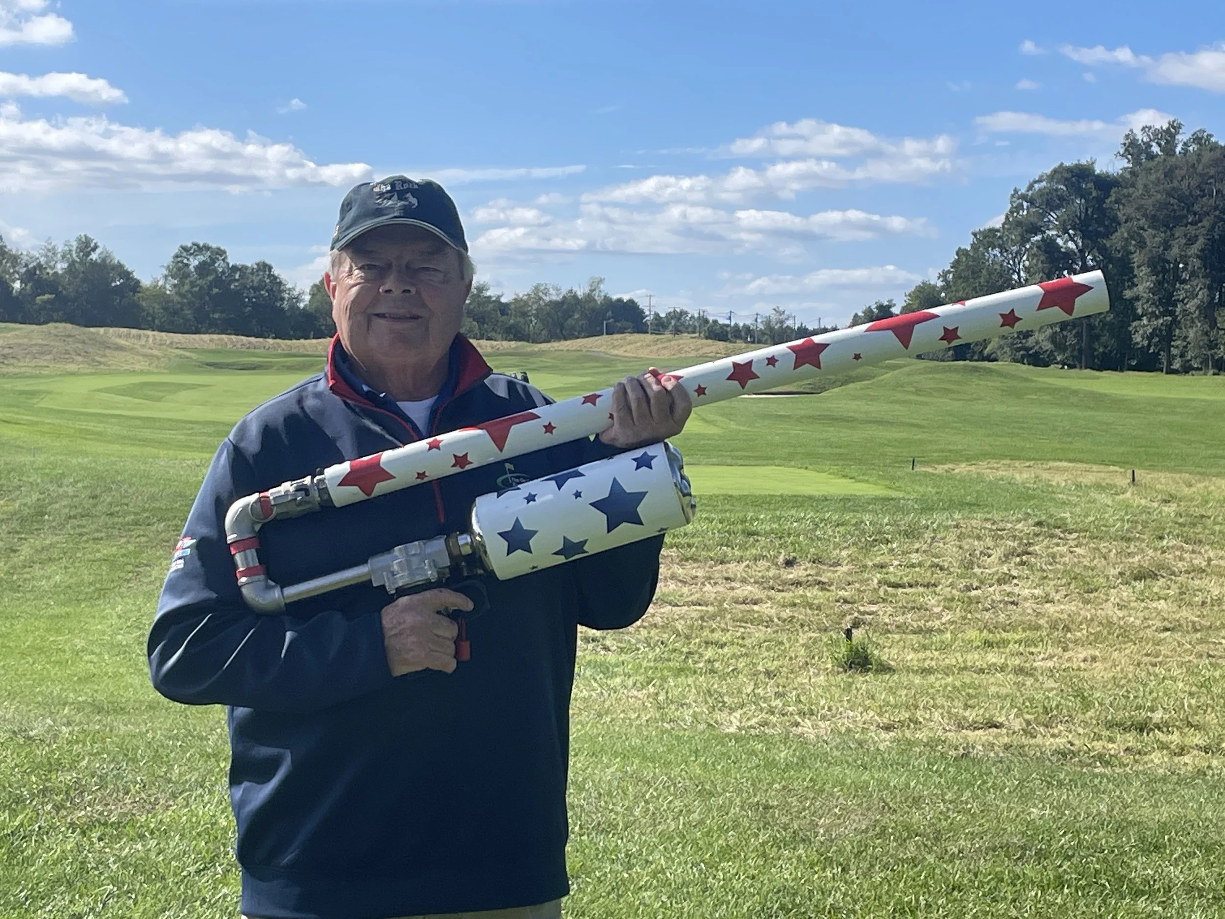 “On Course Experience team member demonstrating a golf ball air cannon at a Maryland golf tournament.”