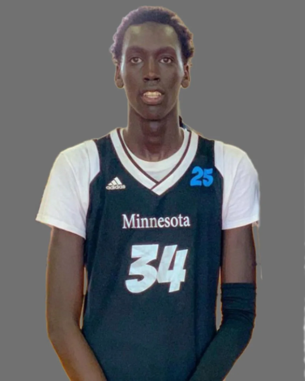 A female volleyball player wearing a Minnesota team jersey with the number 34 and a blue patch with the number 25. She has dark skin and short, curly hair.