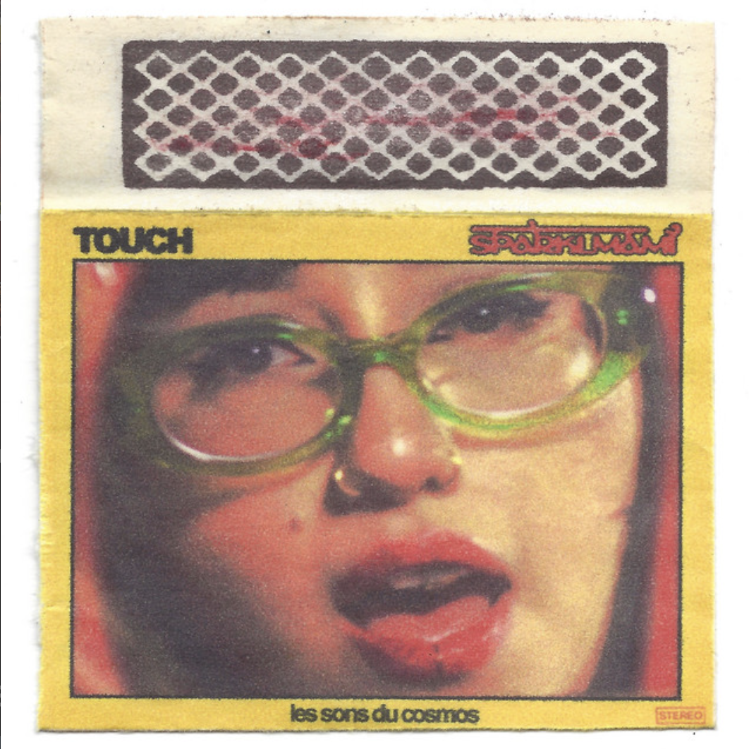 Close-up of a person with green glasses and red lipstick, with an album cover featuring French text and a yellow border.