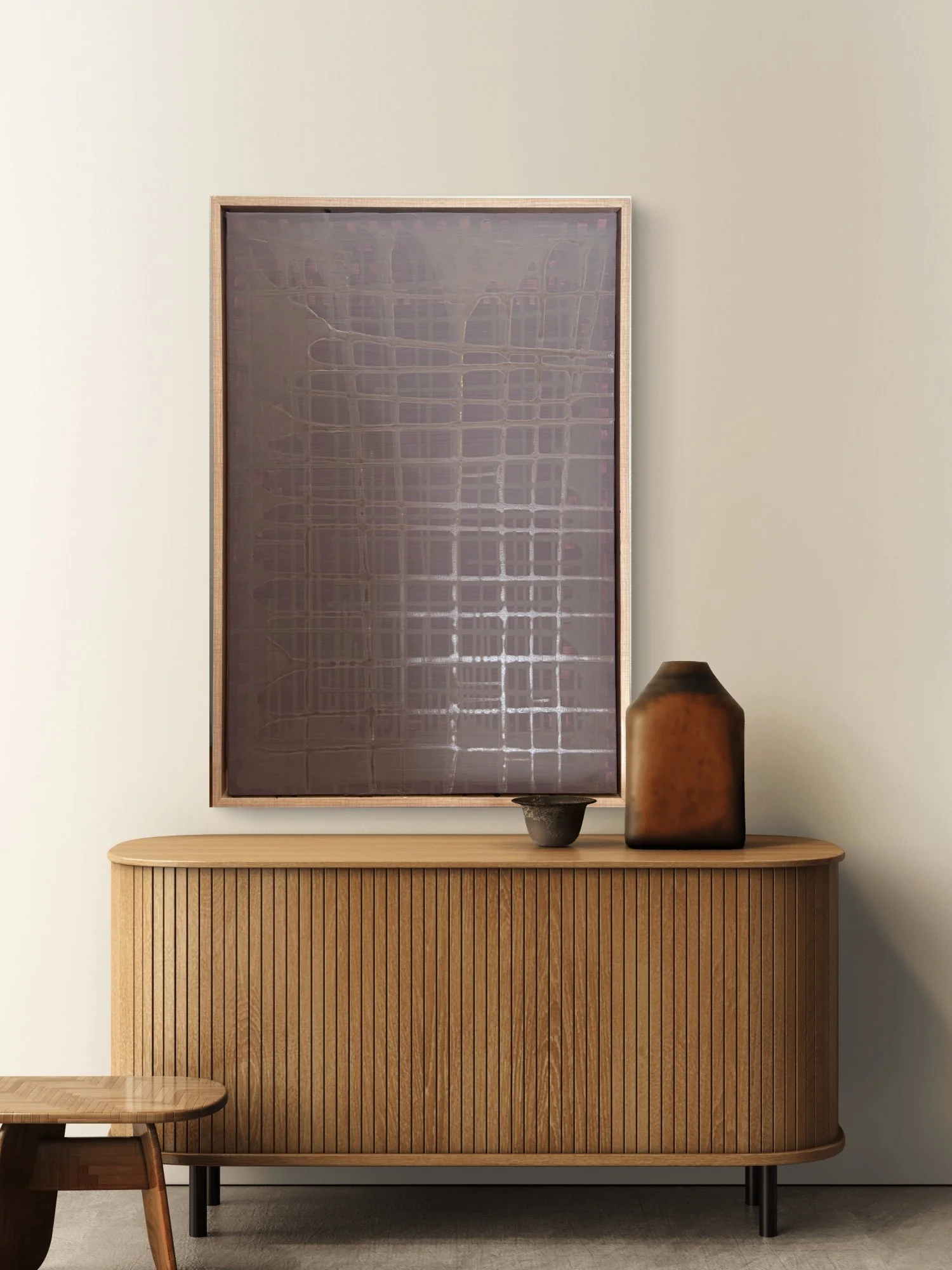 A wooden sideboard with vertical slats, a large framed piece of abstract art with a grid pattern, a small bowl-like object, and a large amber-colored vase on top, against a plain wall.