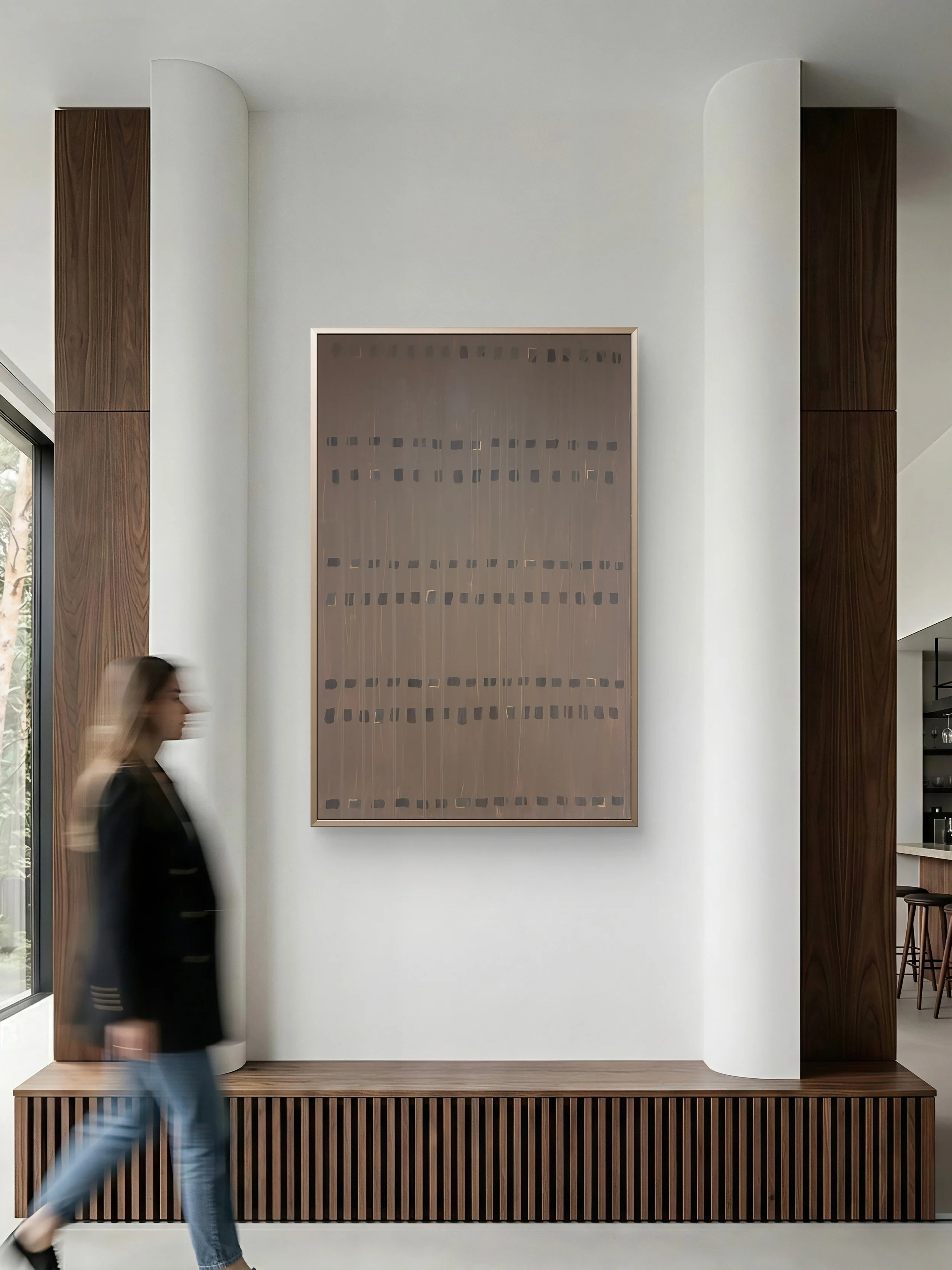 Interior of a modern building with a white wall, dark wooden accents, and a large abstract artwork. A person is walking past, captured in motion.