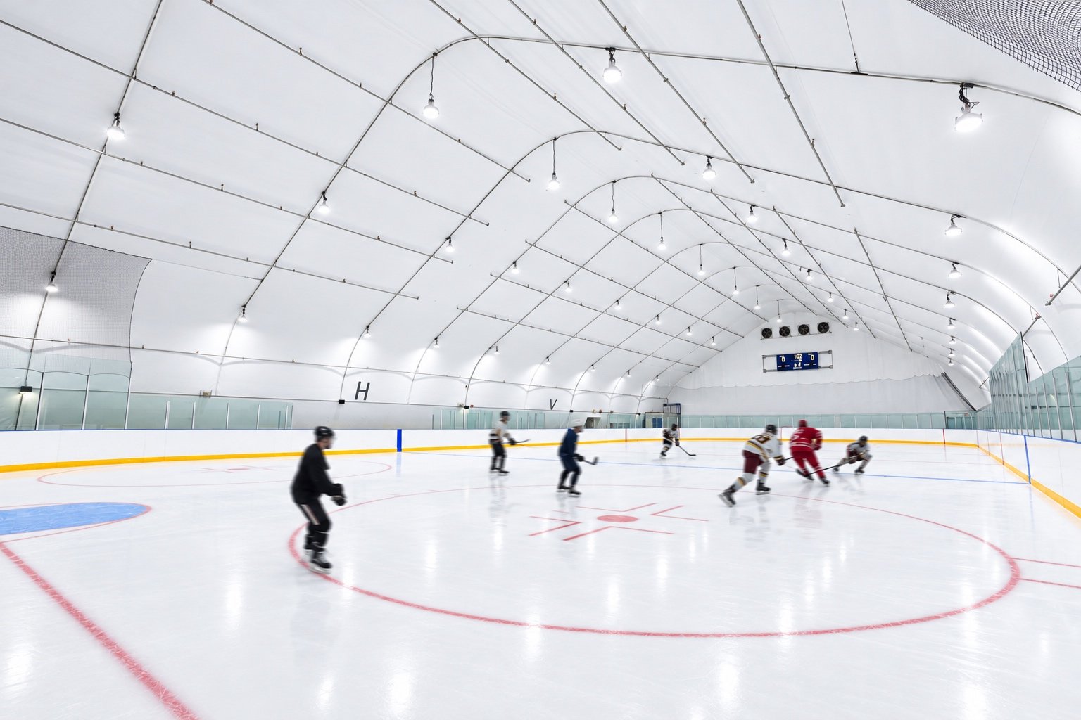Hockey players inside the Ted Reeve Bubble ice rink, a CHERIE NG ARCHITECT INC. (CNA) project.