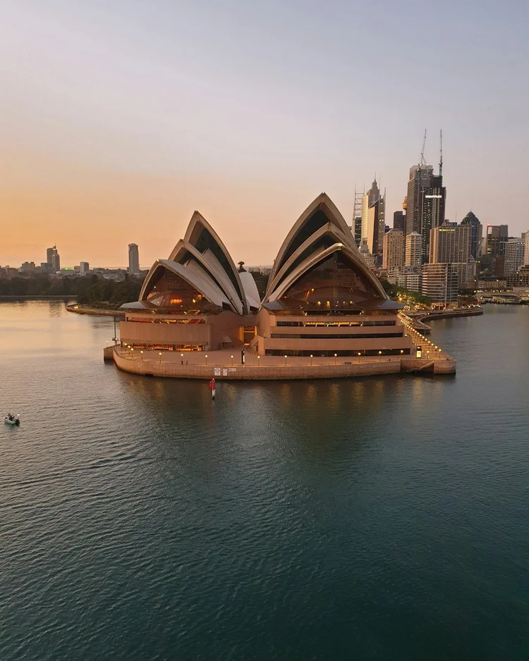 Sydney Opera House and the city skyline across the harbour at golden hour, Sydney, Australia