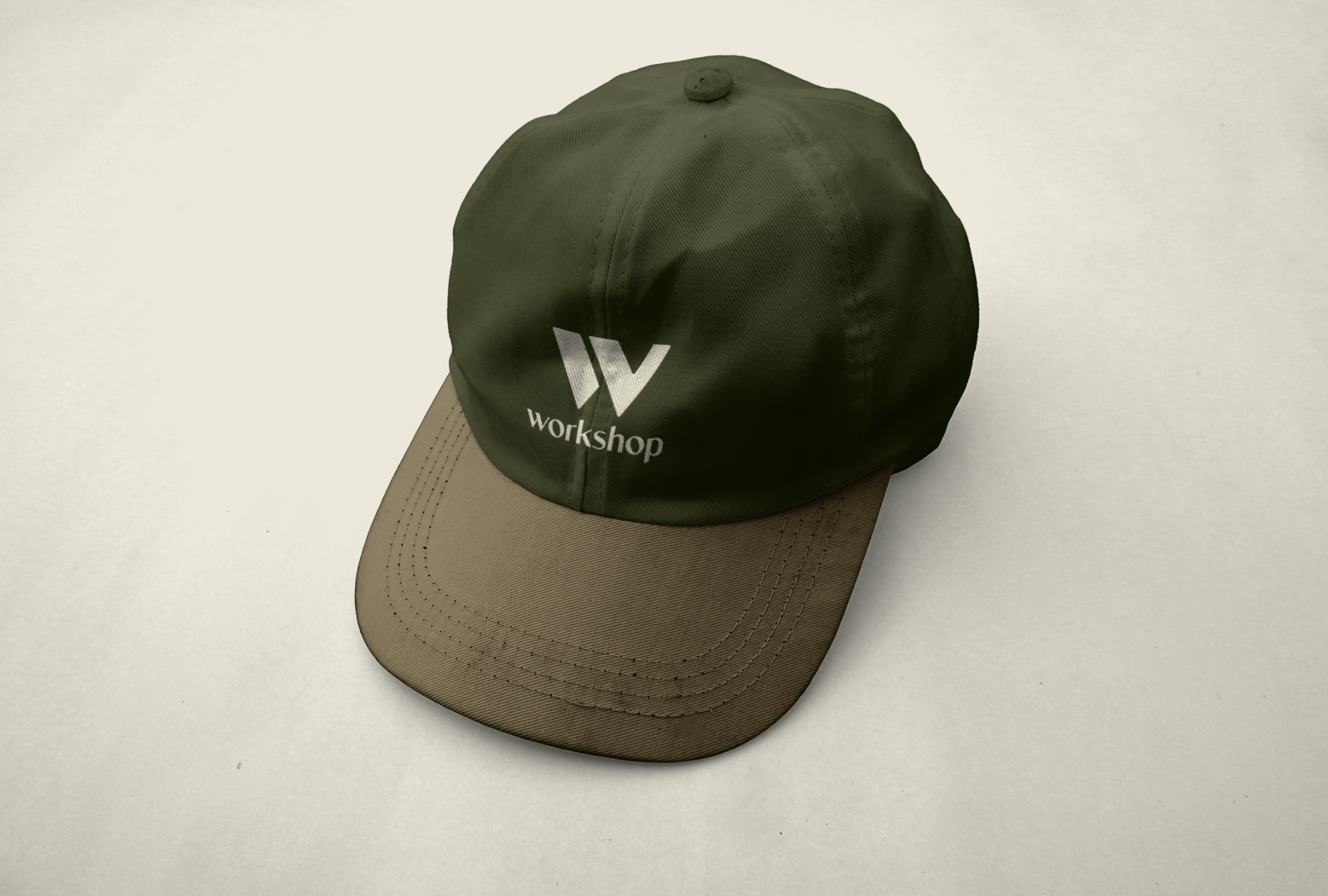 Green and tan Workshop logo baseball cap on a white background