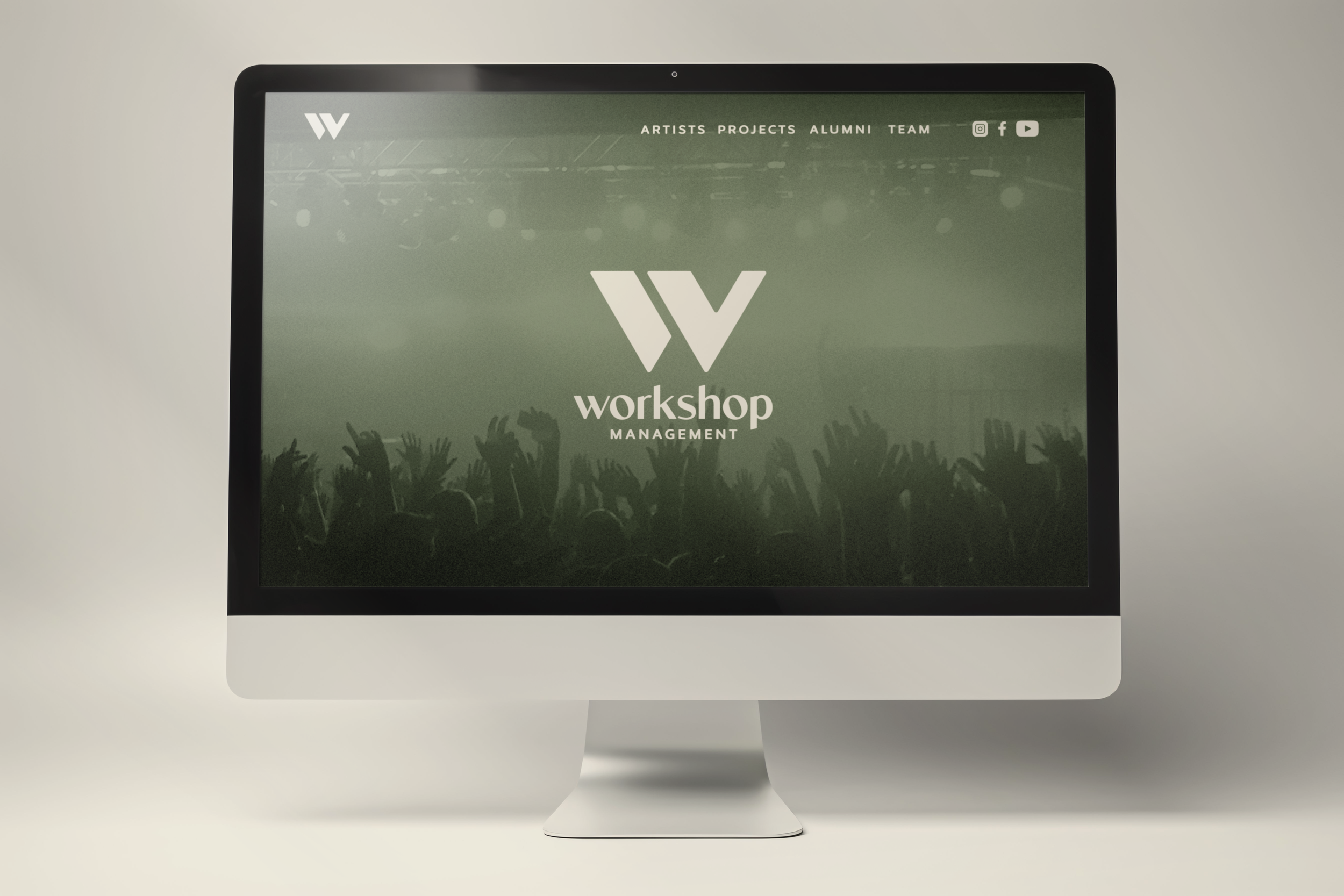Desktop computer displaying the Workshop Management website with a concert crowd background, logo, navigation menu, and social media icons