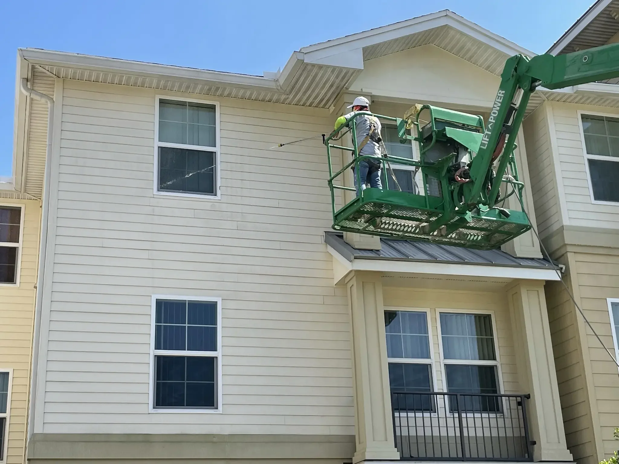 Commercial exterior building washing and multi-story soft wash siding cleaning using boom lift in Sarasota FL