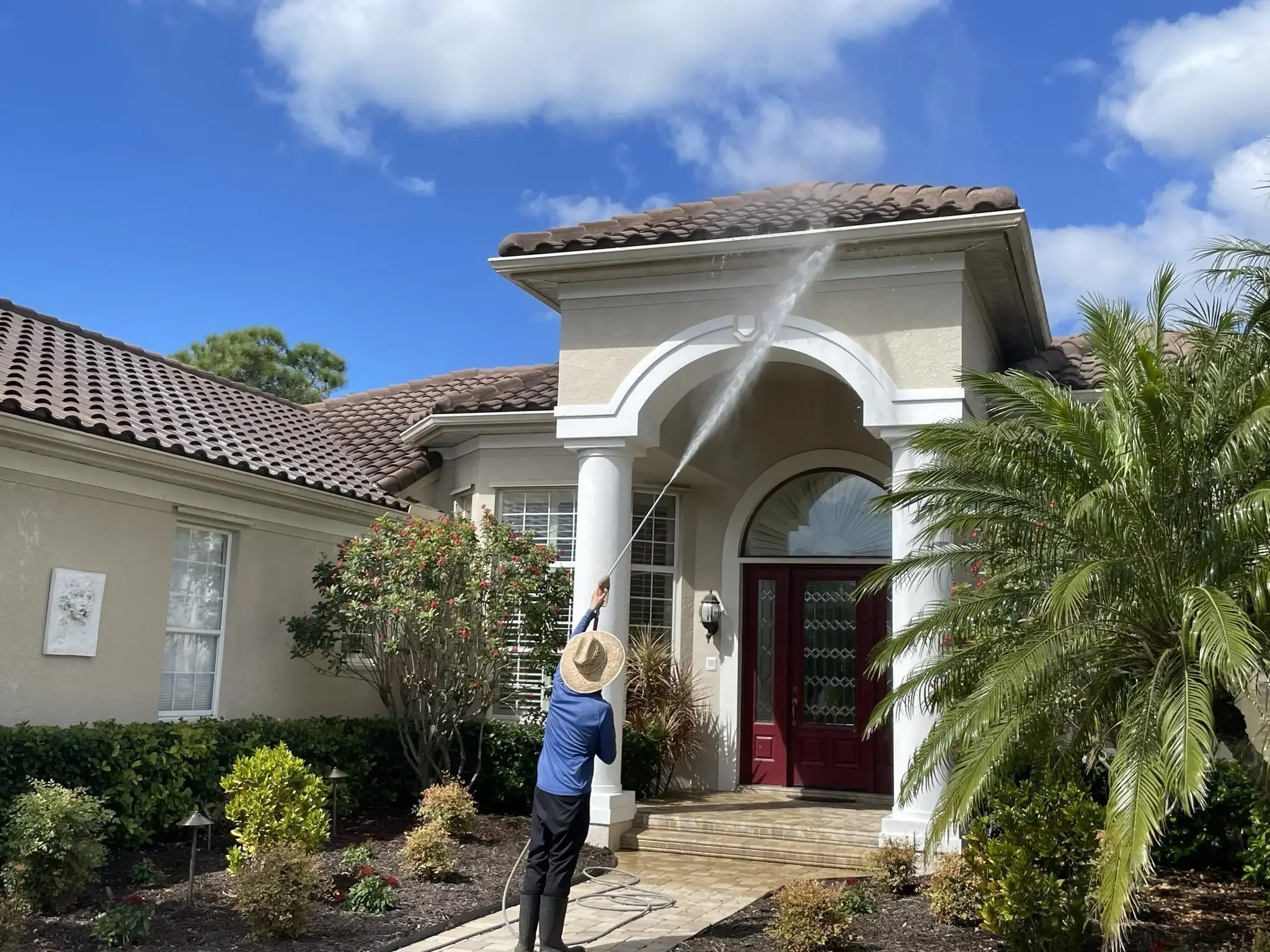 Low-pressure soft wash house washing on residential stucco exterior, fascia, and entryway columns in Sarasota FL
