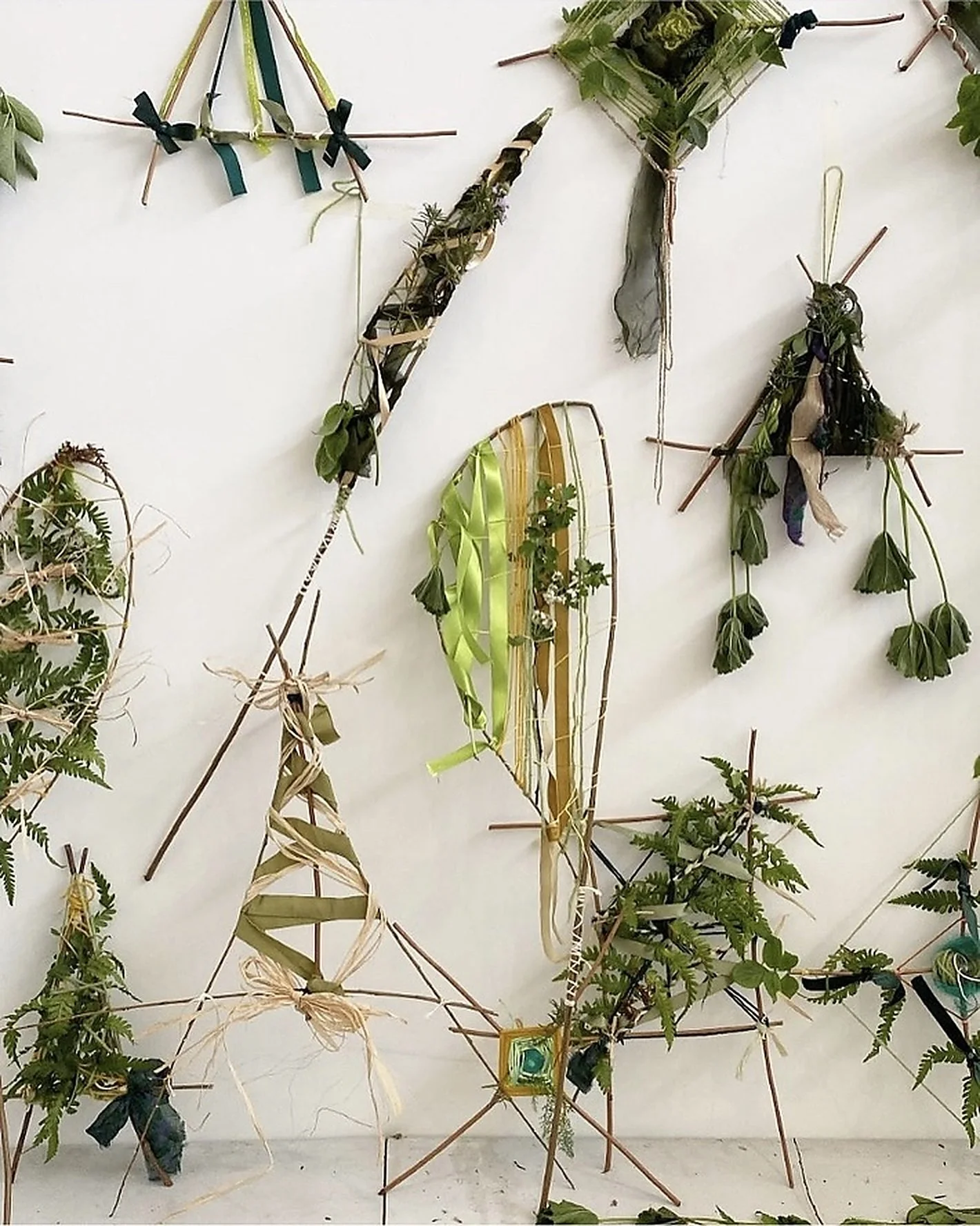 Assemblages of branches, leaves, ribbons and foraged natural materials arranged by Hannah Lees and May Hands, displayed together during To Be Here With You at Southwark Park Galleries, London.