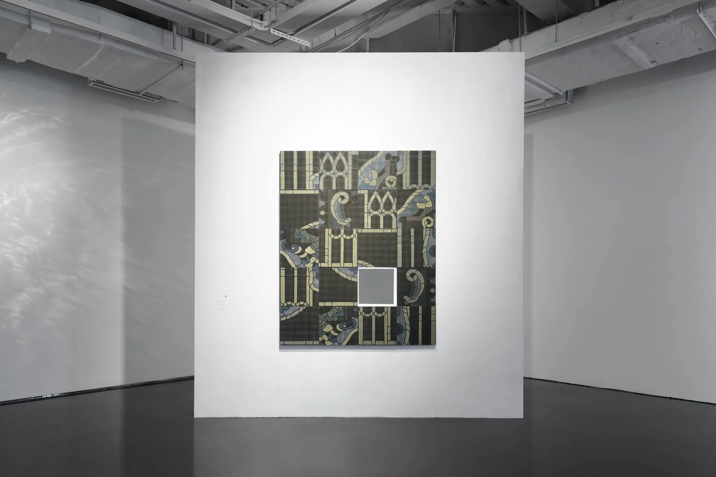 Installation view of Puzzle Piece by Zhi Wei in Danwei Unfolding (2025) at TANK Shanghai, featuring a geometric composition of interlocking architectural patterns in black, gold and muted green, displayed on a freestanding white gallery wall.