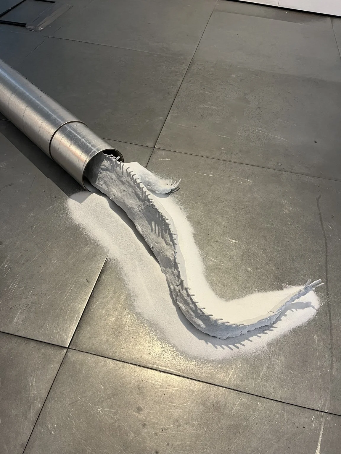 Anastasia Belinskaya, No Place To Hide (2026), installed in Commencement / Commandment at Prokofiev Studio, London. A sculptural work combining a reclaimed British Antarctic Survey ice-core storage container, clay and white silica sand, extending acr