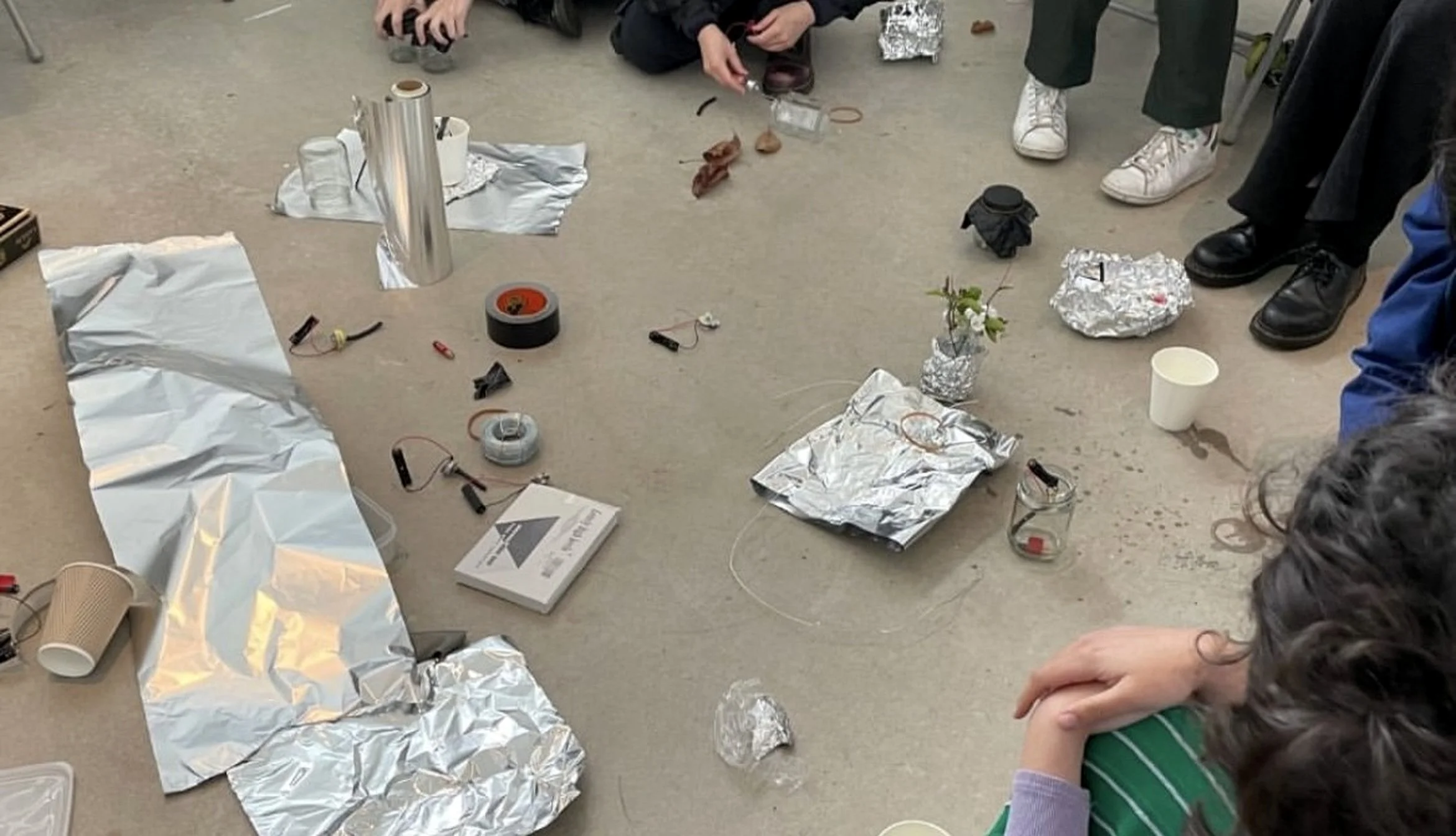 Participants creating experimental musical sculptures using everyday materials during a sound workshop led by Rie Nakajima for To Be Here With You at Southwark Park Galleries, London.
