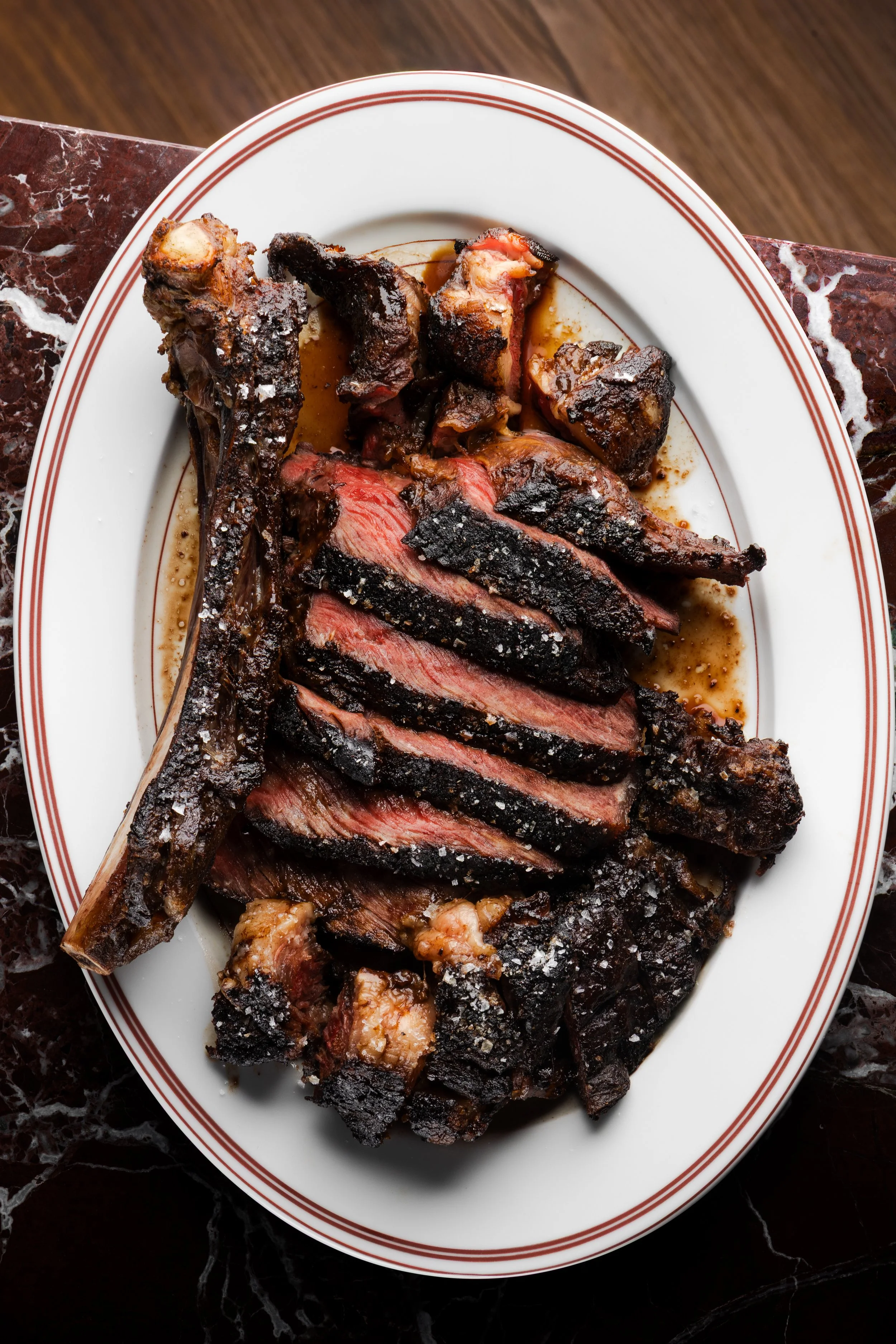 Costillas asadas servidas en un plato sobre una mesa oscura.