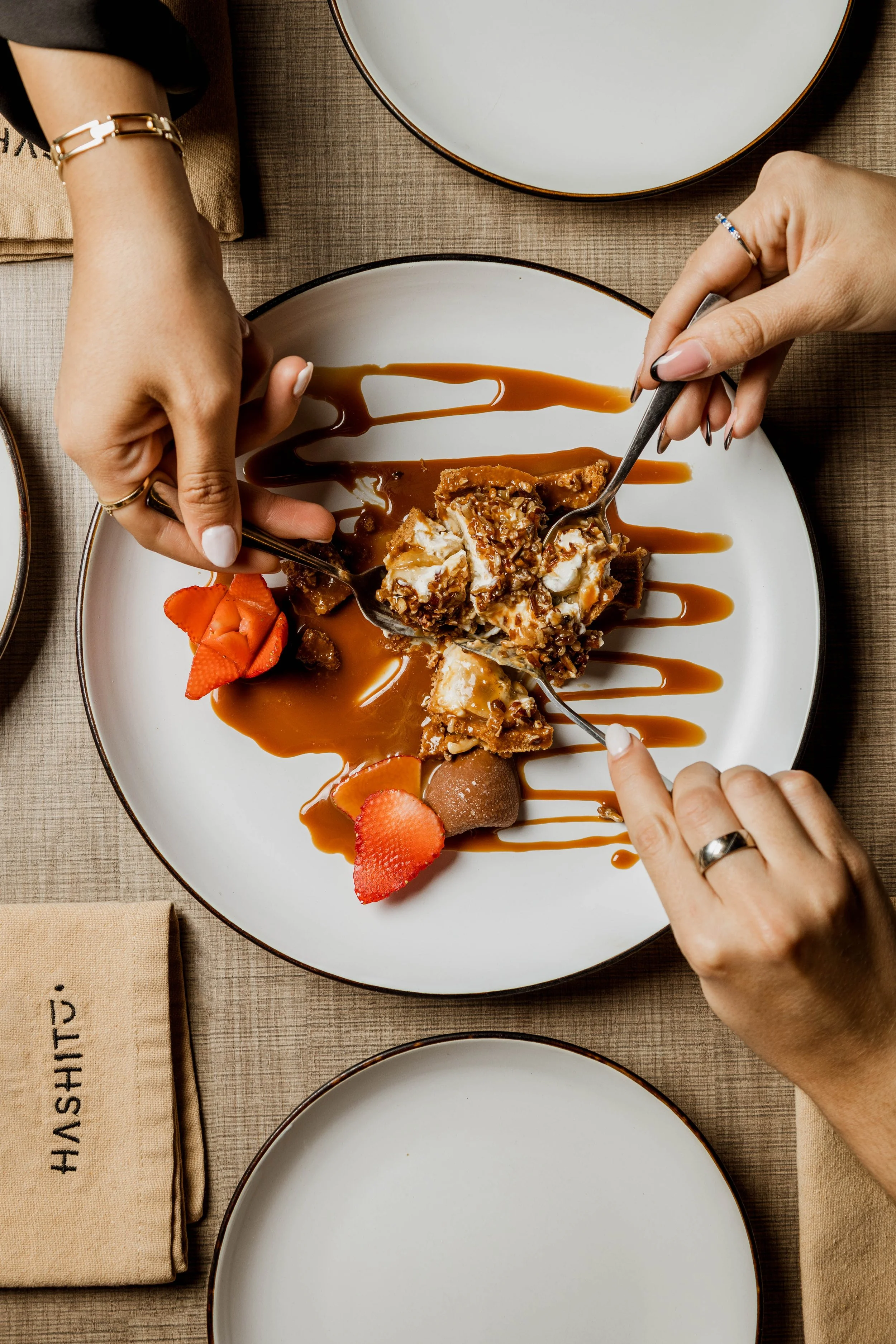 Postre con salsa de caramelo y fresas servido en una mesa.
