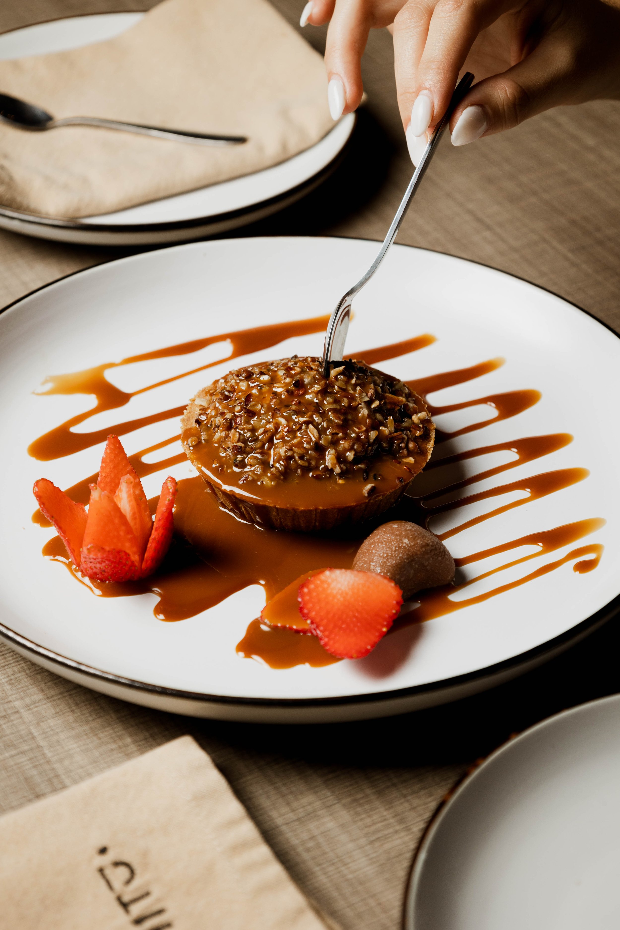 Postre con salsa de caramelo, nueces y fresas.