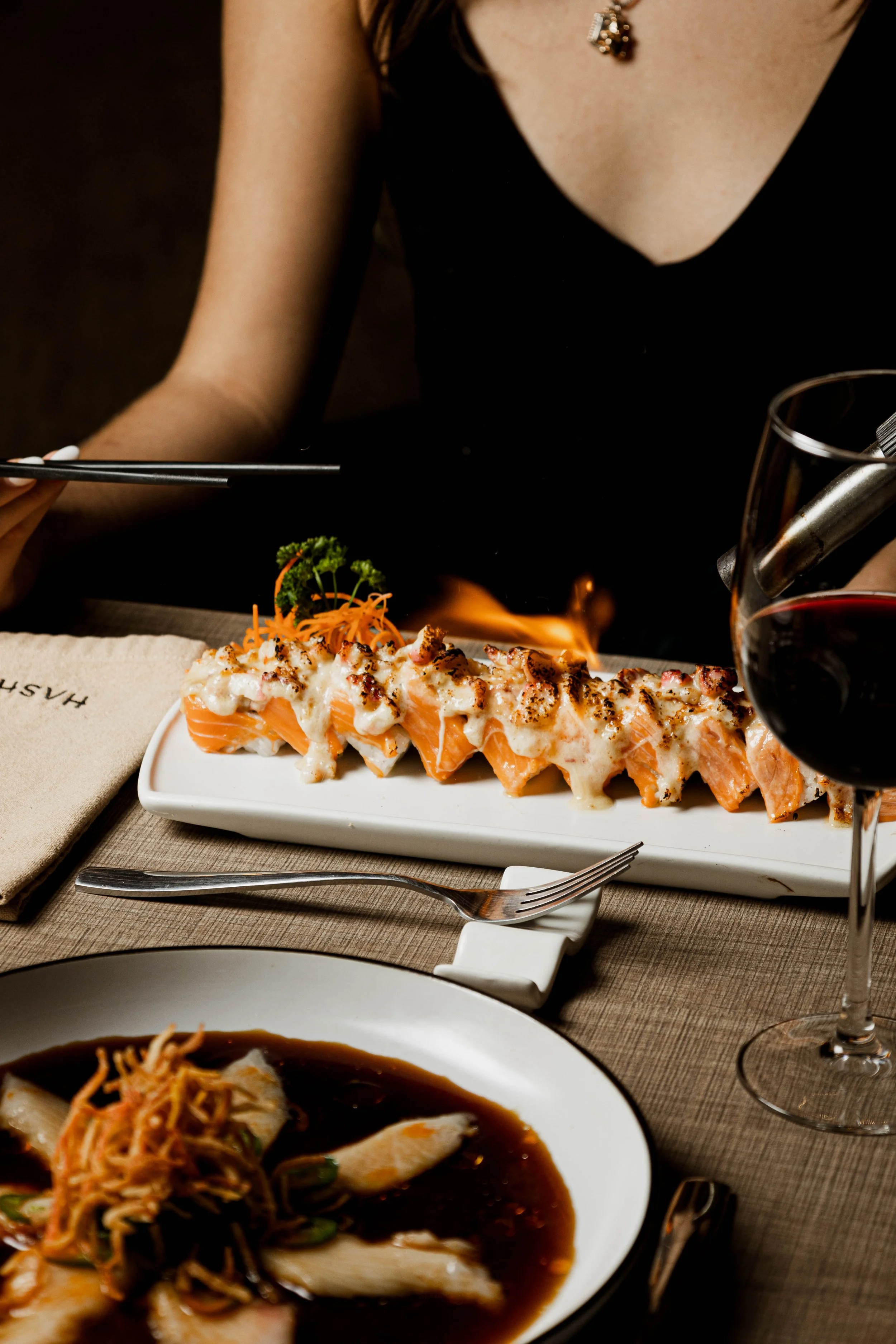 Platillos y copa de vino en una mesa de restaurante.
