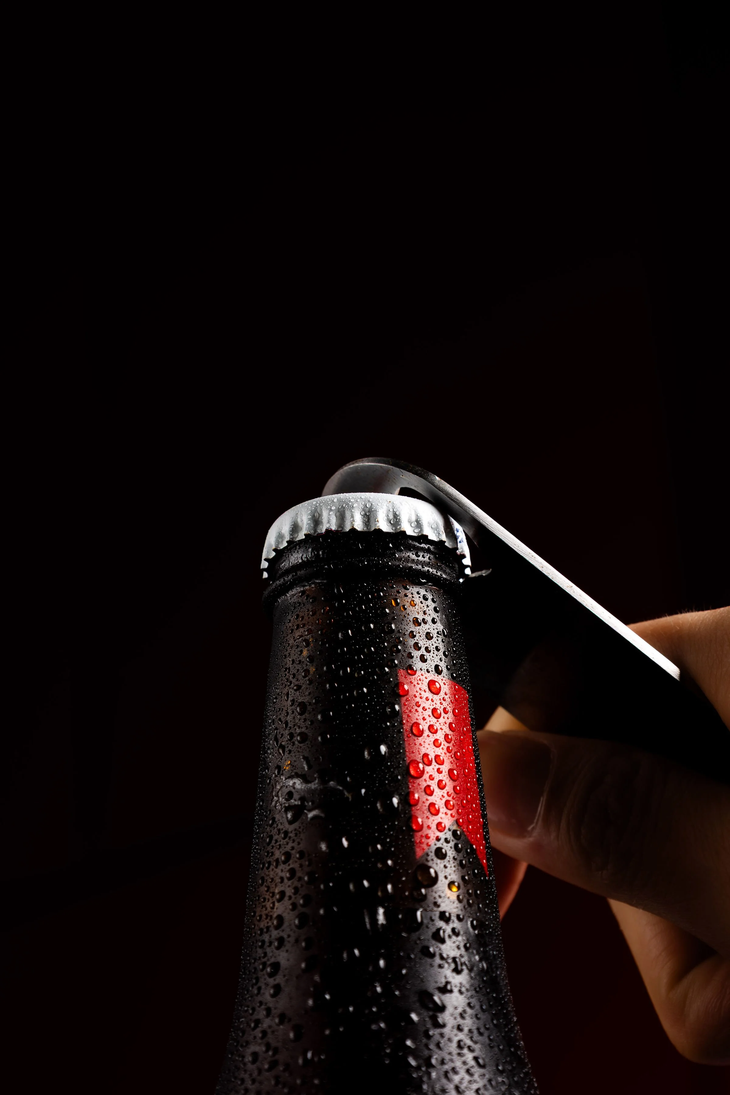 Detalle de una botella fría y un destapador.