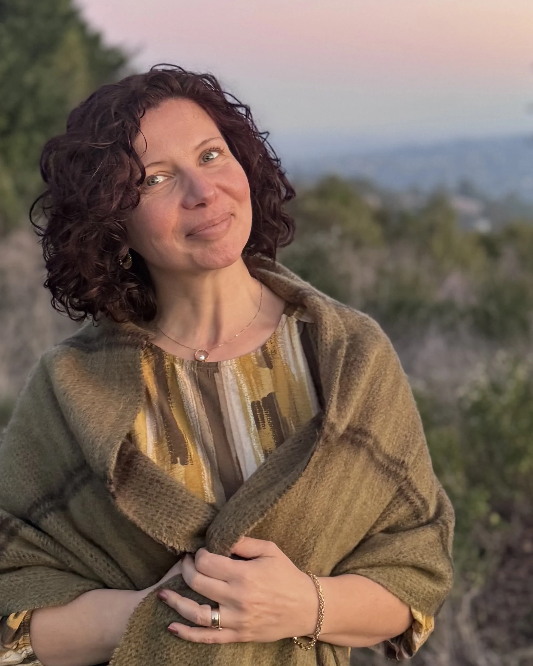 Irina Neymark, Associate Marriage and Family Therapist, smiling outdoors in a natural setting.