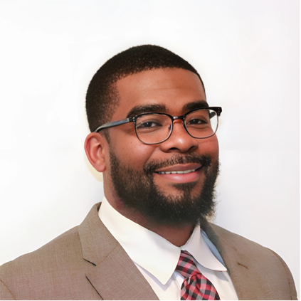 Portrait of a smiling man wearing glasses and a suit with a white shirt and a patterned tie.