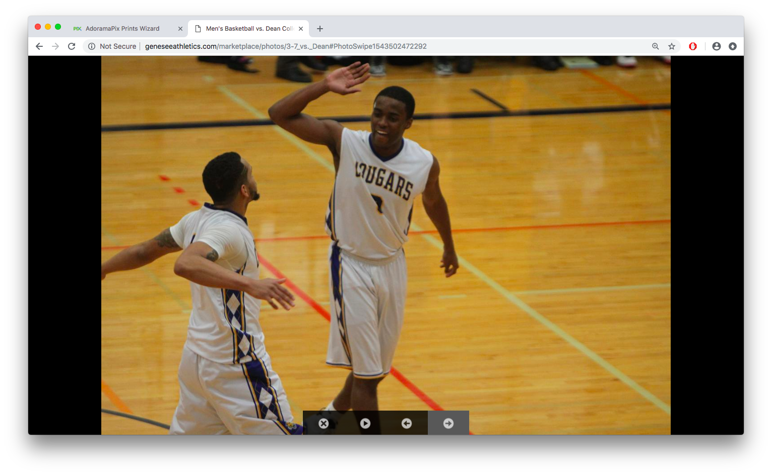 Two basketball players from the Cougars team celebrating on the court during a game.