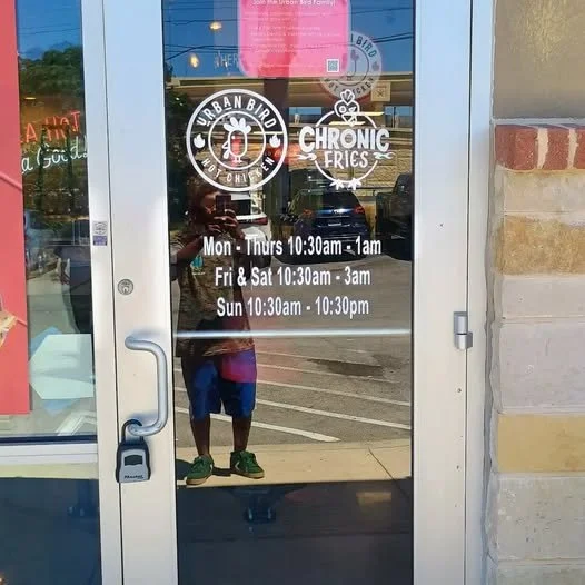 Storefront door with hours of operation and logos for Urban Bird and Chronic Fries.