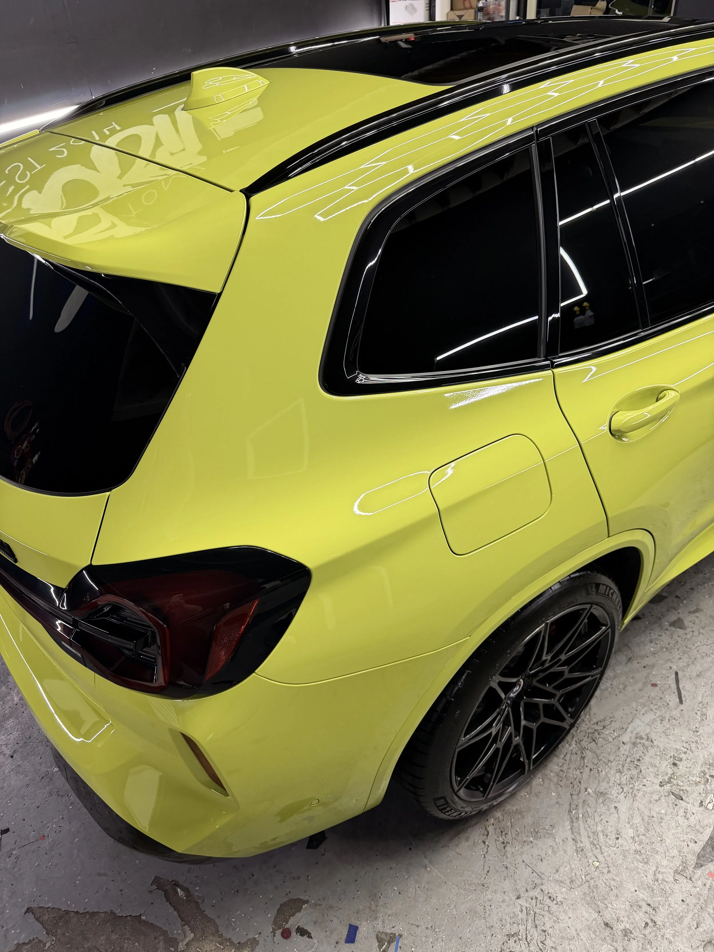 Lime green SUV with ceramic window tint and black wheels at Xclusive Auto Customz in Santee, CA