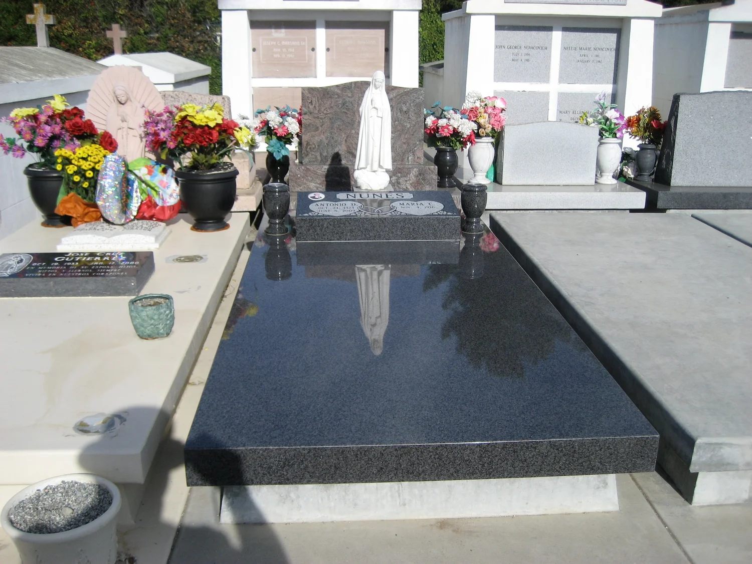 Installed granite ledger memorial with a statue and matching vases, by Wallace Memorial
