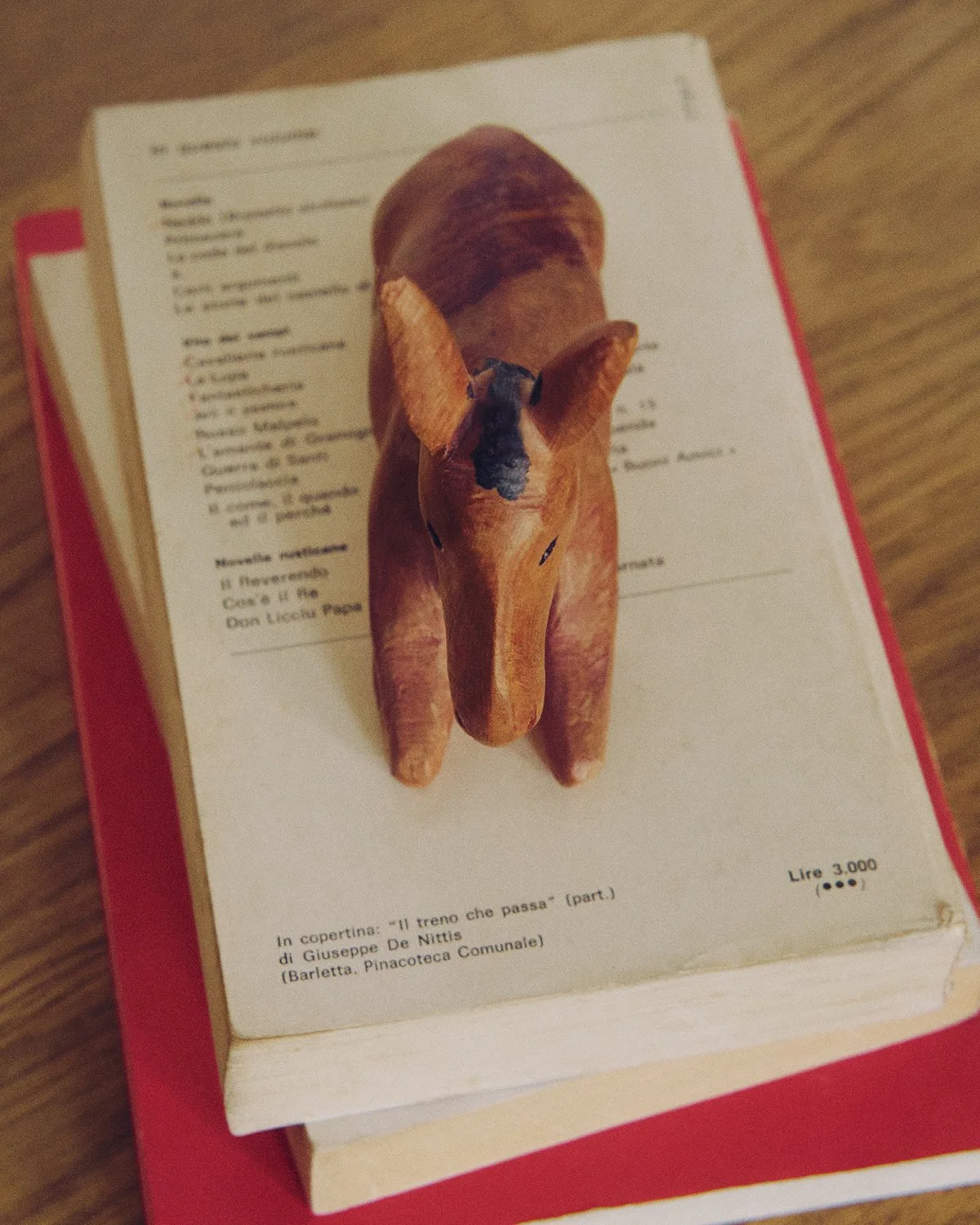 A small wooden model of a pig placed on top of a printed page from a book or magazine.