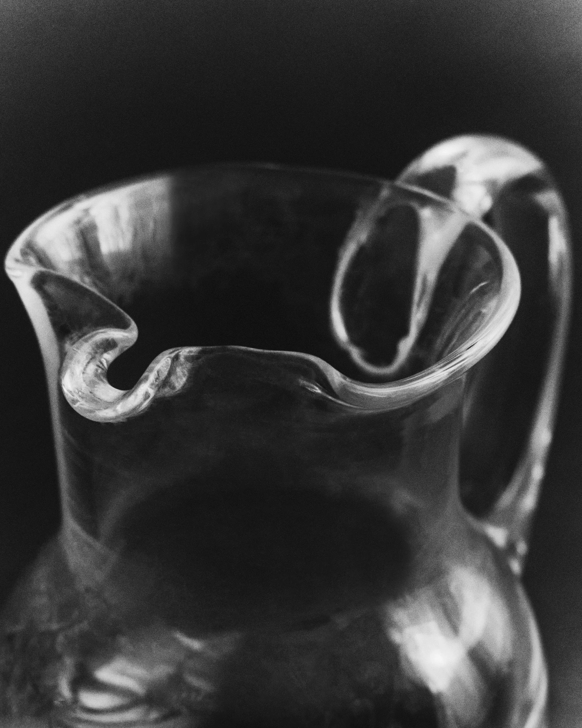 Close-up of a cracked glass cup or bowl against a dark background.
