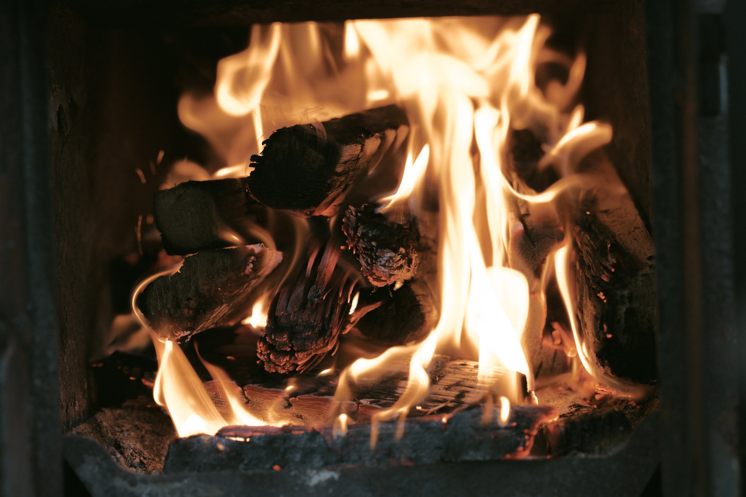 Ein Feuer in einem Kamin mit brennenden Holzscheiten.