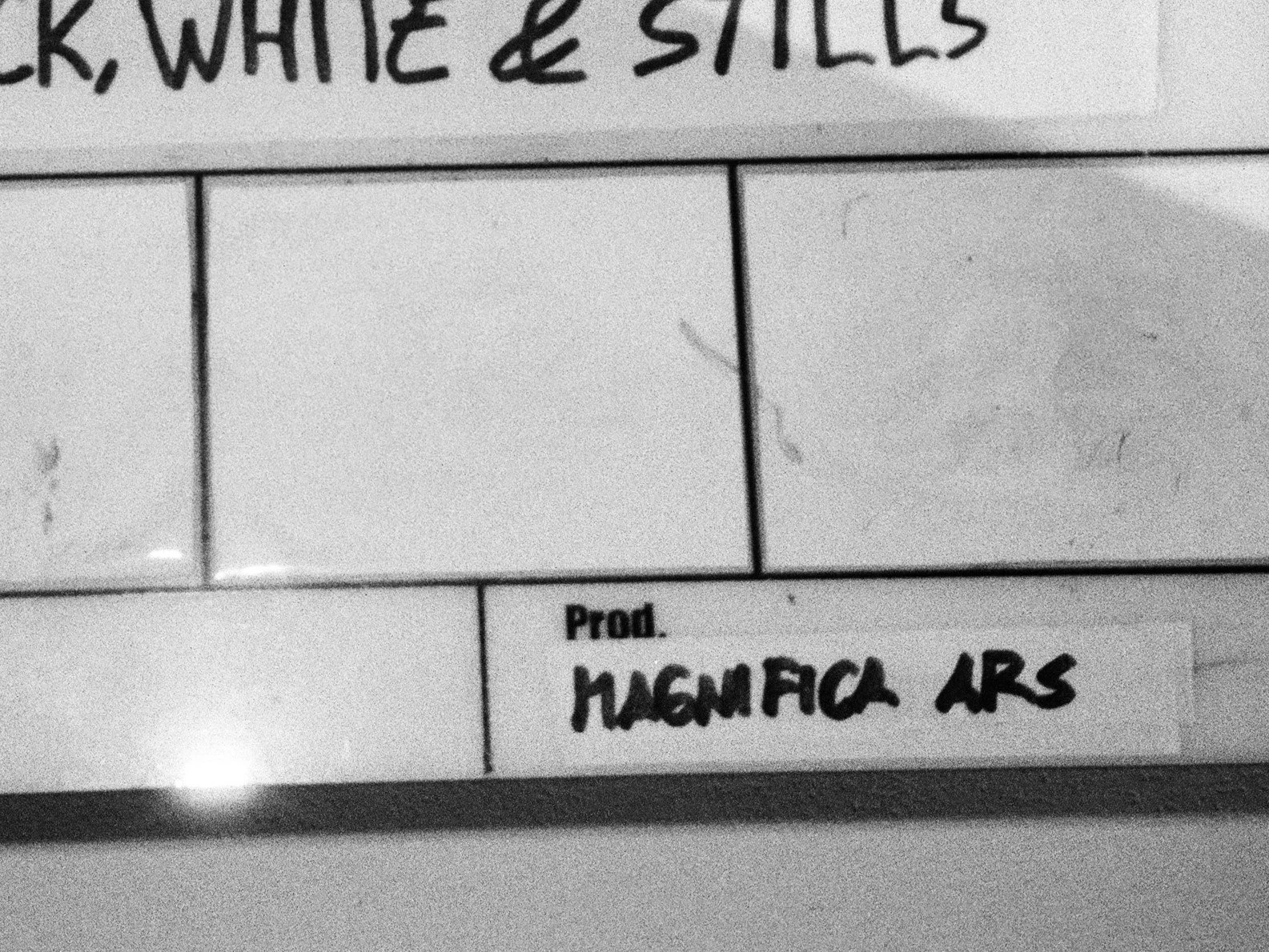 Immagine in bianco e nero realizzata su pellicola 35mm ILFORD FP4 Plus 125, che ritrae la parte in basso a destra di un ciak (o clapperboard), su cui vediamo il nome di Magnifica Ars Films.