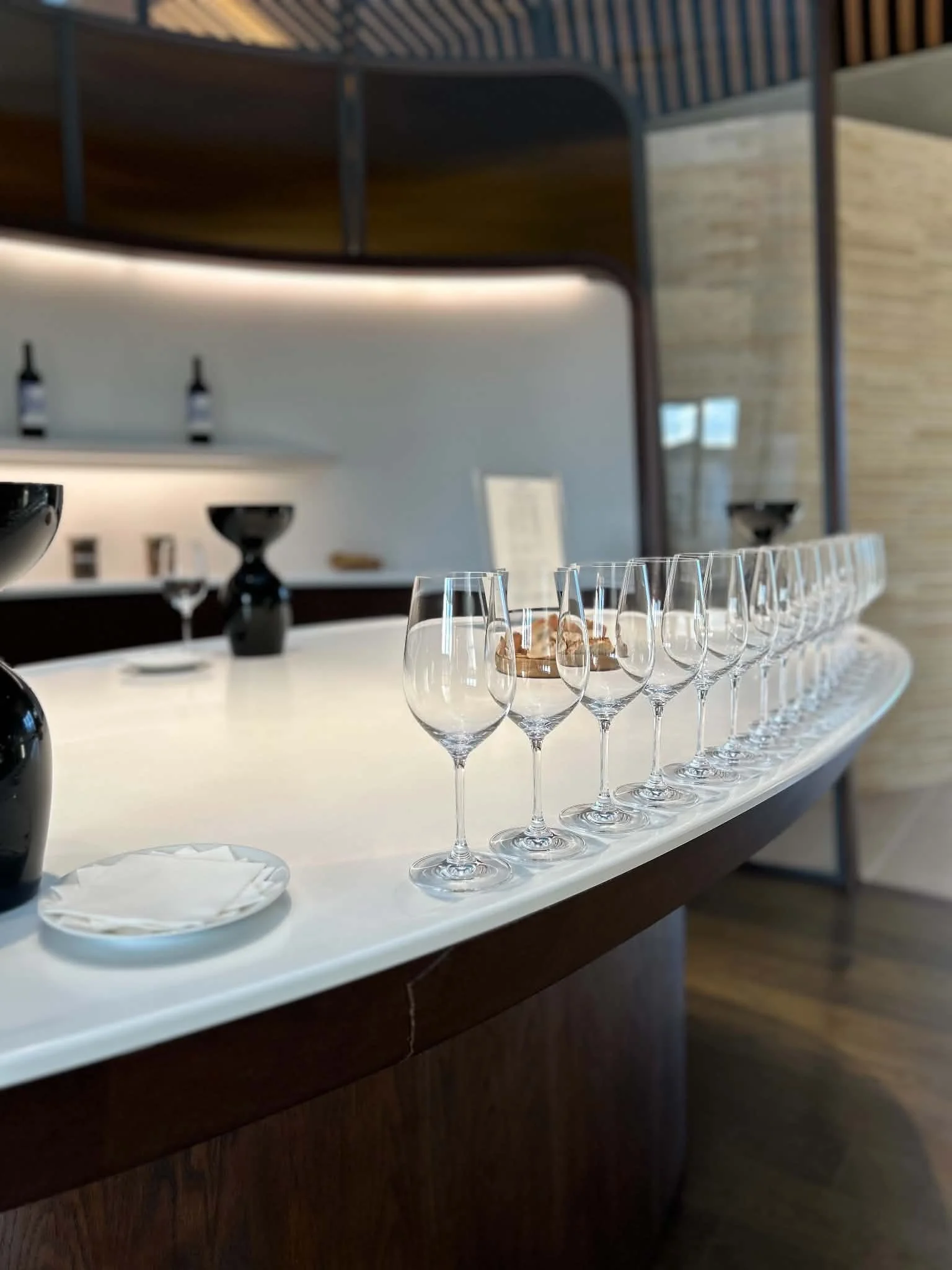 Row of empty champagne glasses on a white table in a modern interior space.
