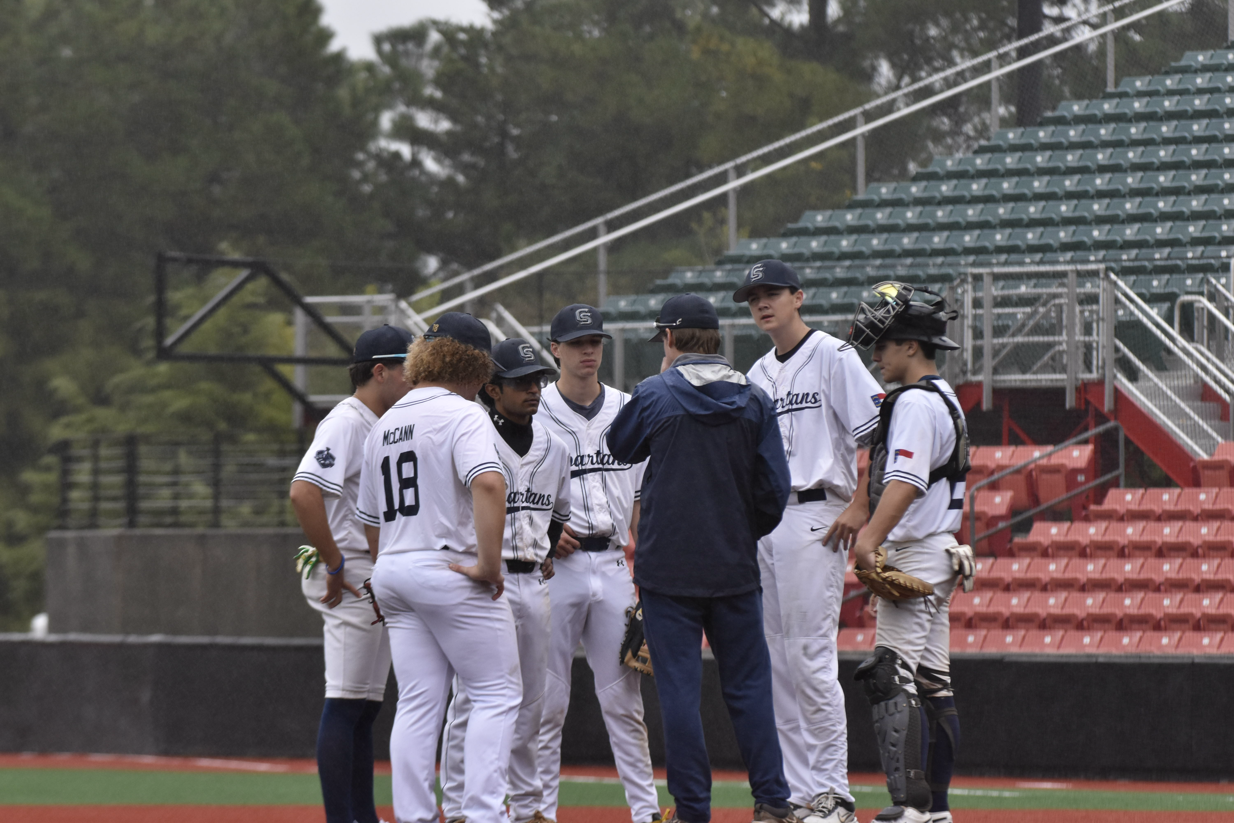 Coach visiting the mound with infielders joining