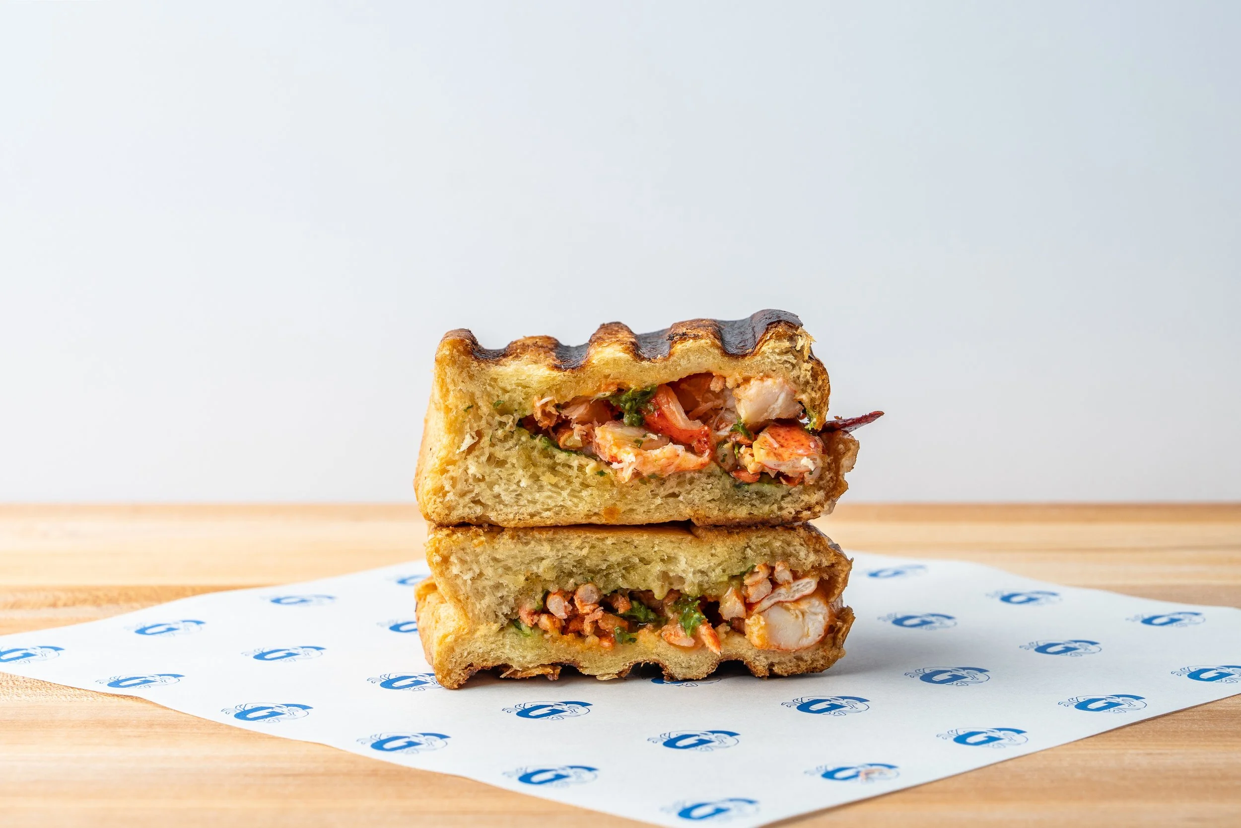Grilled lobster sandwich cut open to show the filling