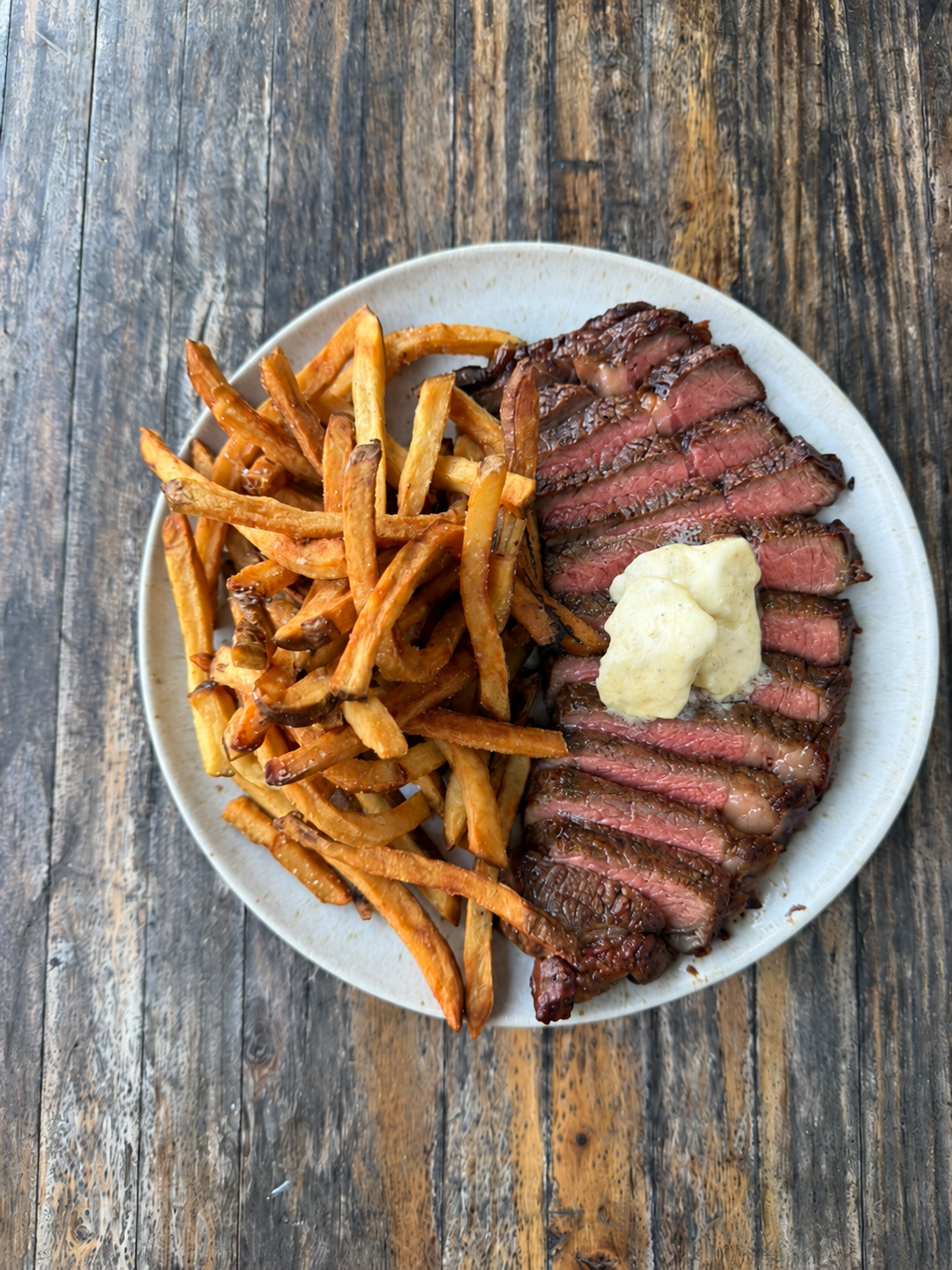 Rosy medium-rare steak with fries.png