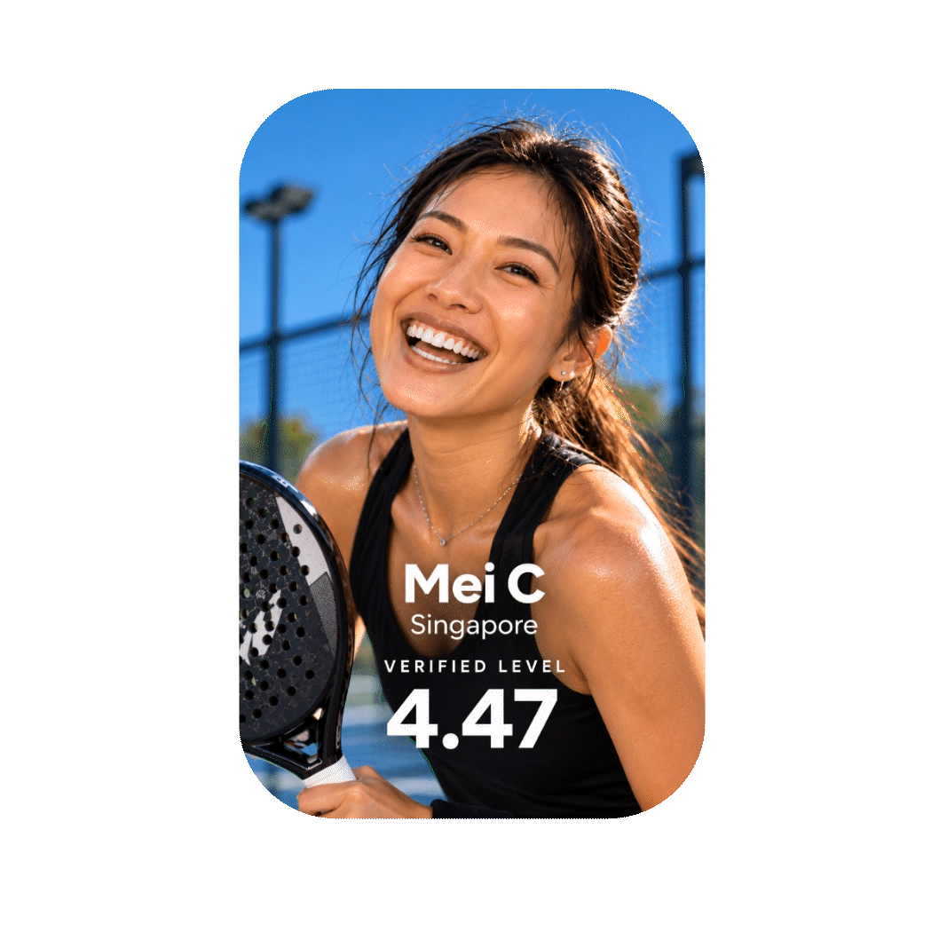 Smiling woman holding pickleball paddle at outdoor court with blue sky.